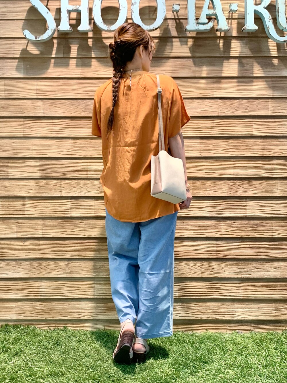 オレンジ系のシャツ/ブラウス、ブルー系のデニムパンツ、ベージュ系のショルダーバッグを着用したレディースの秋コーディネートの5枚目の写真