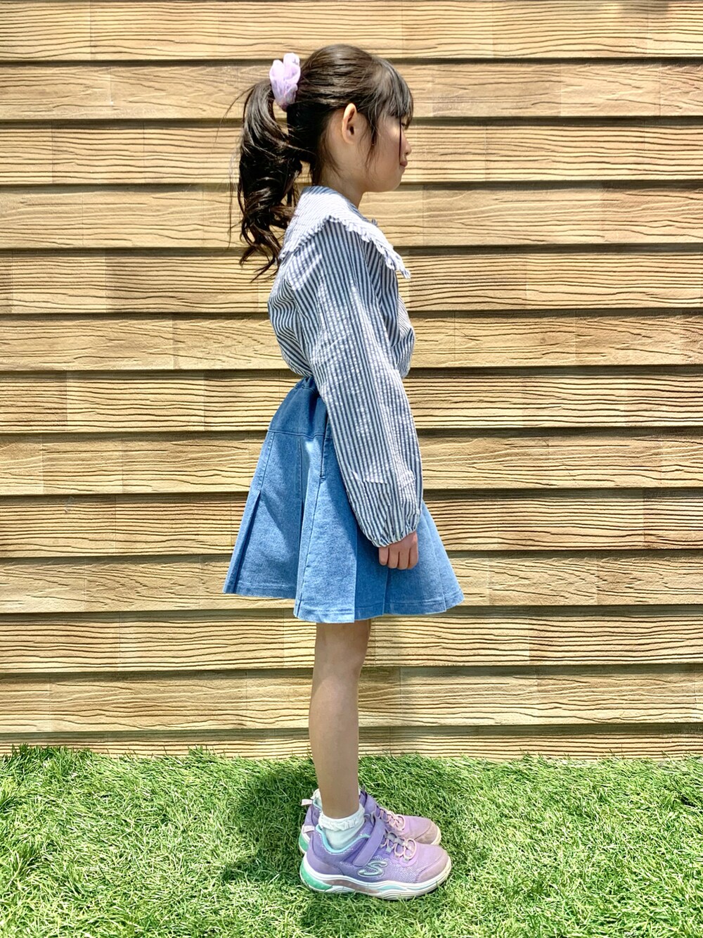 ブルー系のシャツ/ブラウス、ブルー系のデニムスカート、パープル系のトートバッグを着用したキッズの春コーディネートの3枚目の写真