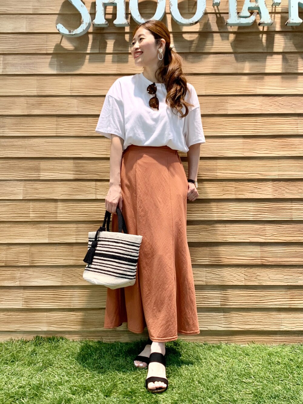 ホワイト系のTシャツ/カットソー、オレンジ系のスカート、ブラック系のトートバッグを着用したレディースの夏コーディネートの2枚目の写真