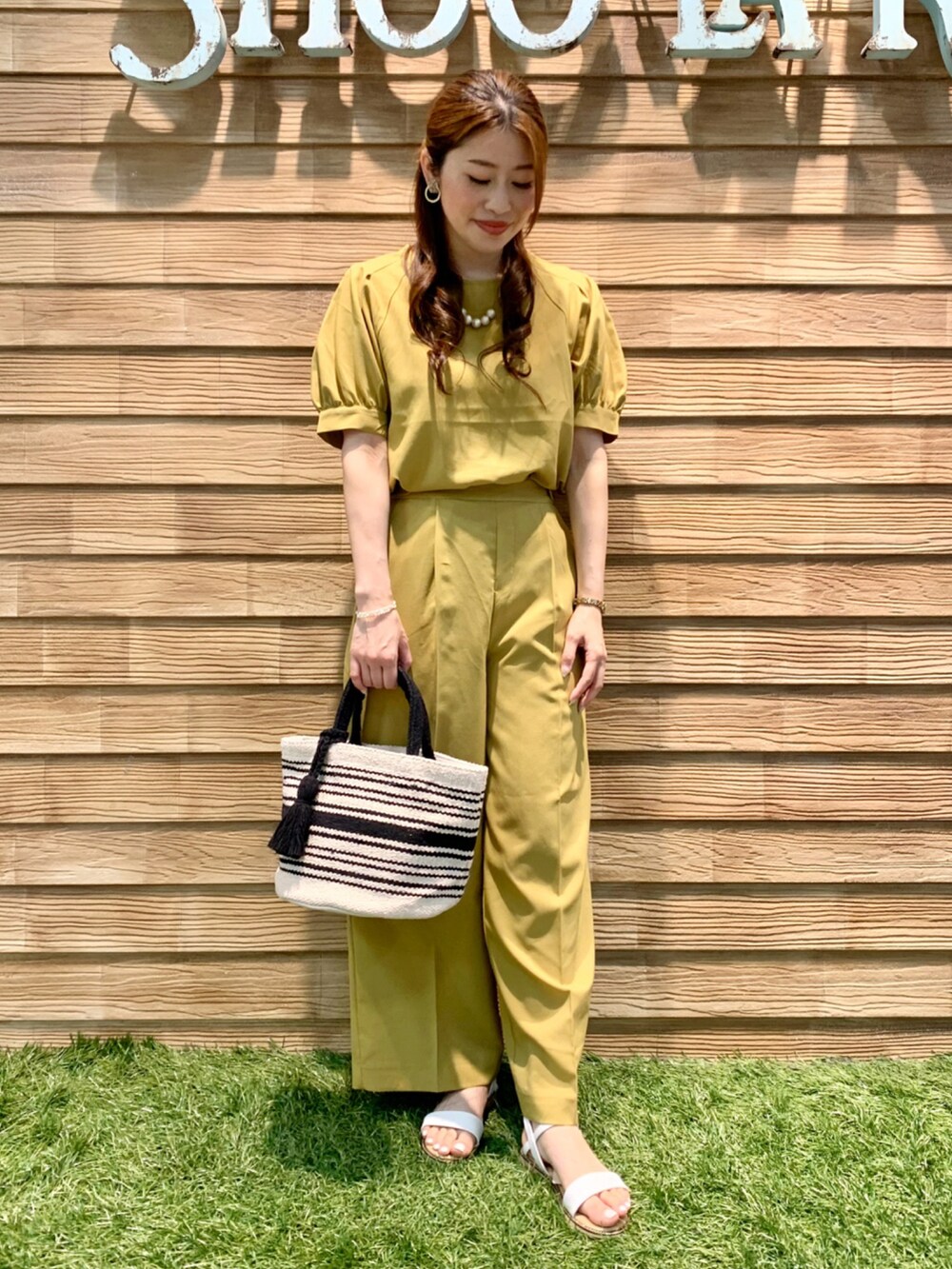 イエロー系のシャツ/ブラウス、イエロー系のその他パンツ、ブラック系のトートバッグを着用したレディースの夏コーディネートの3枚目の写真