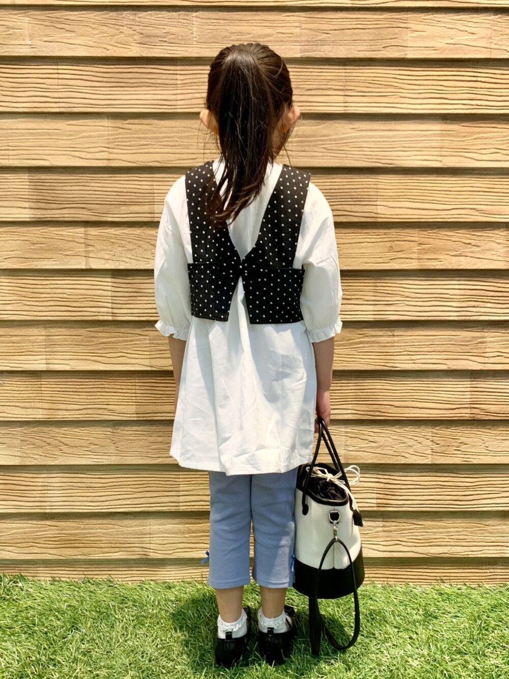 ブラック系のワンピース、ブルー系のその他パンツ、ブラック系のハンドバッグを着用したキッズの春コーディネートの5枚目の写真