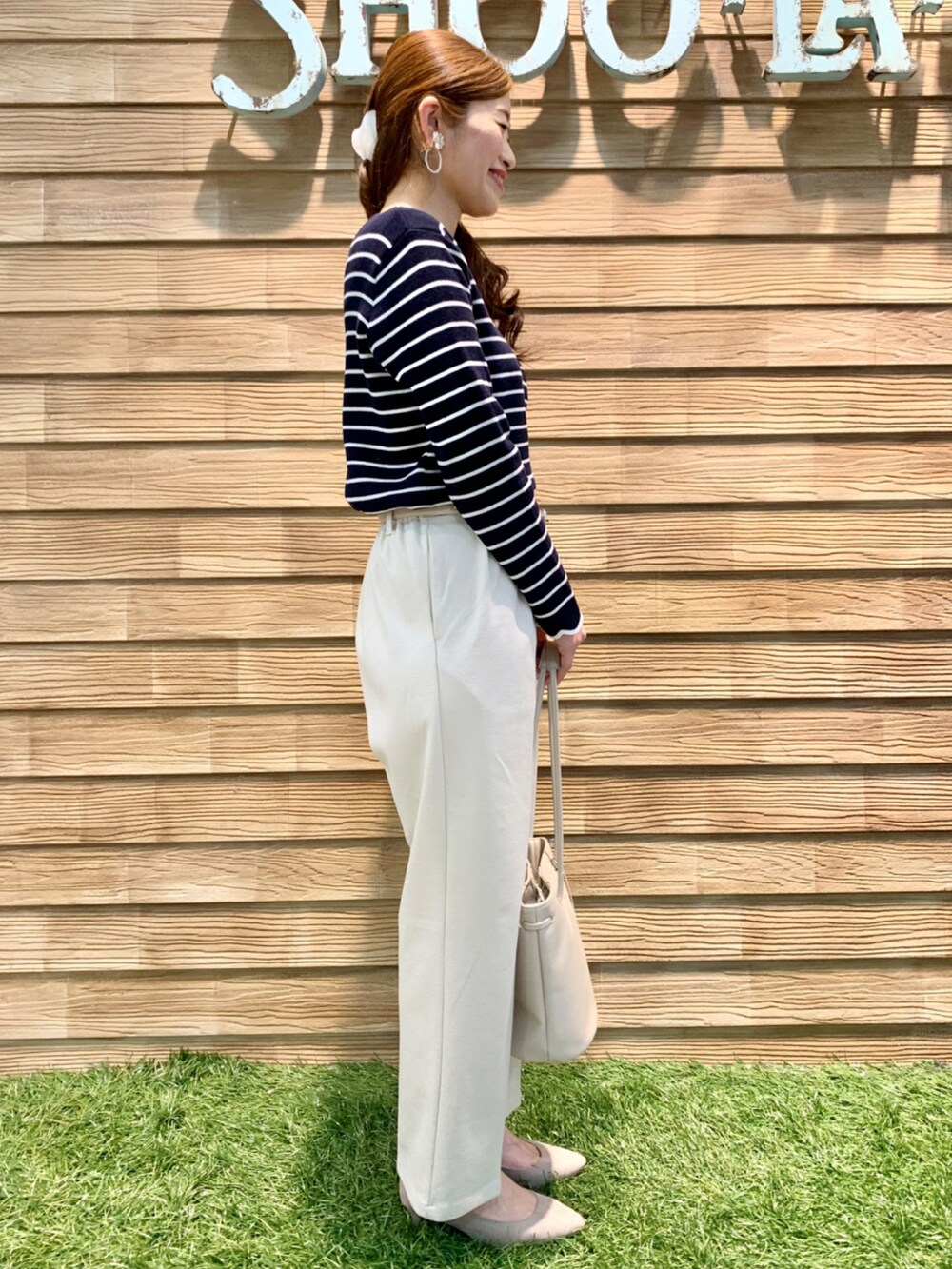 ブルー系のニット/セーター、ホワイト系のその他パンツ、ホワイト系のトートバッグを着用したレディースの春コーディネートの5枚目の写真