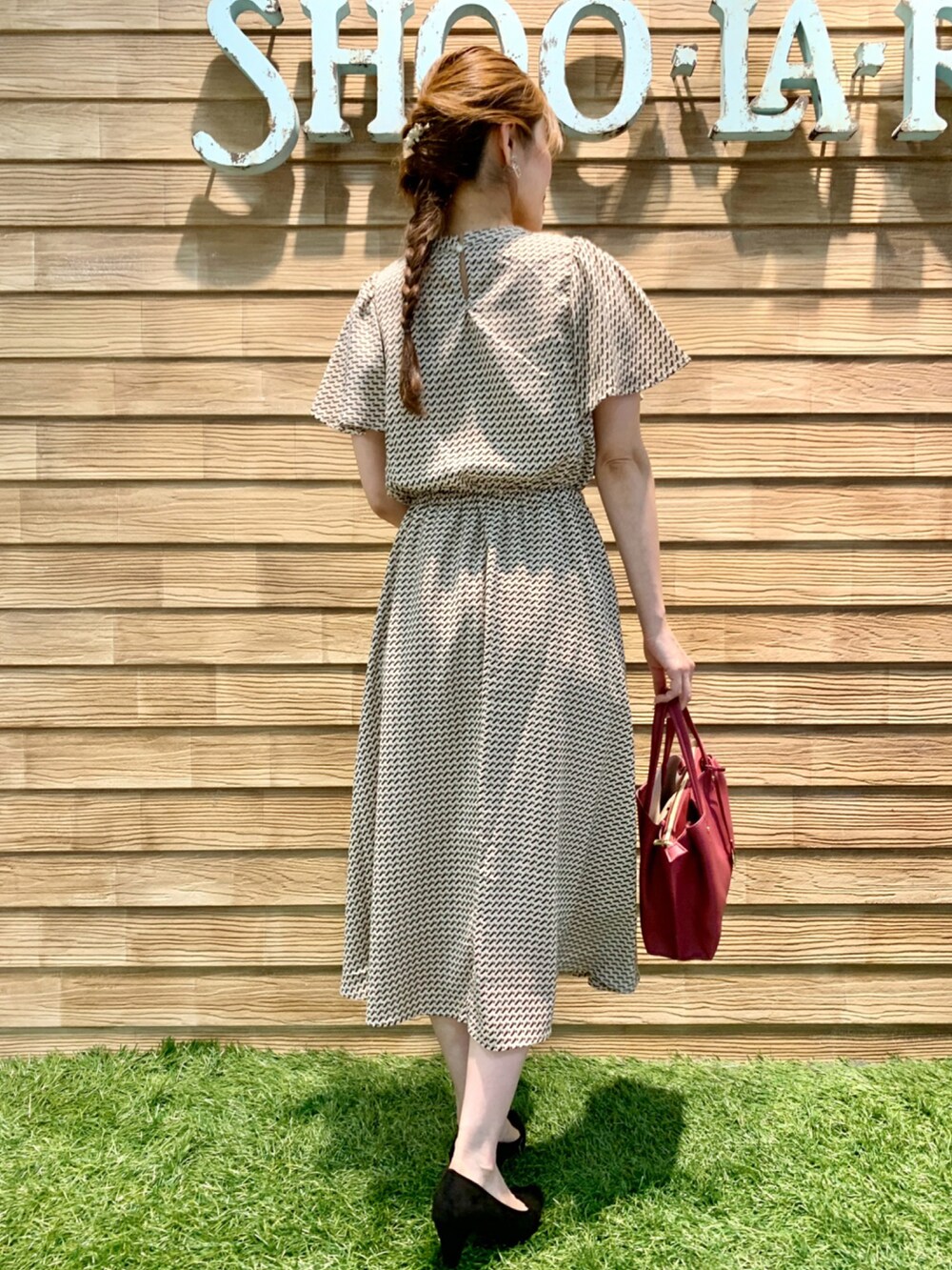ベージュ系のワンピース、ピンク系のトートバッグ、ブラック系のパンプスを着用したレディースの秋コーディネートの5枚目の写真