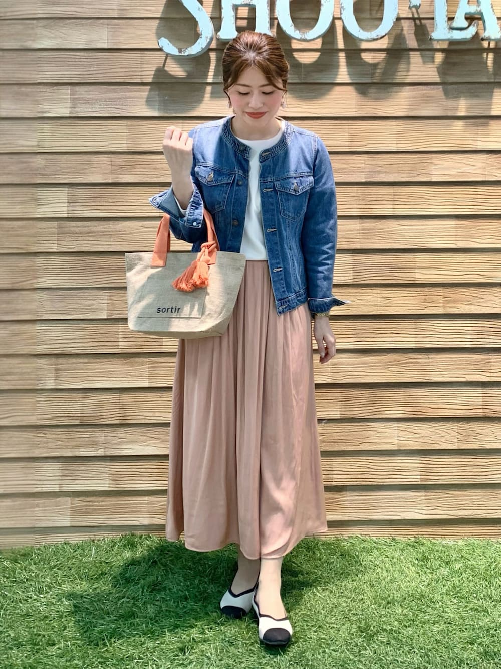 ブルー系のデニムジャケット、ベージュ系のTシャツ/カットソー、オレンジ系のスカートを着用したレディースの春コーディネートの2枚目の写真