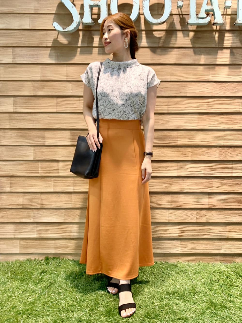 ホワイト系のシャツ/ブラウス、オレンジ系のスカート、ブラック系のショルダーバッグを着用したレディースの秋コーディネートの2枚目の写真