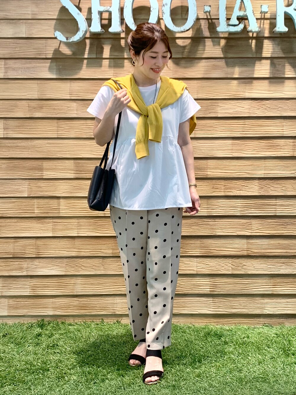 イエロー系のカーディガン/ボレロ、ホワイト系のTシャツ/カットソー、ベージュ系のその他パンツを着用したレディースの秋コーディネートの2枚目の写真