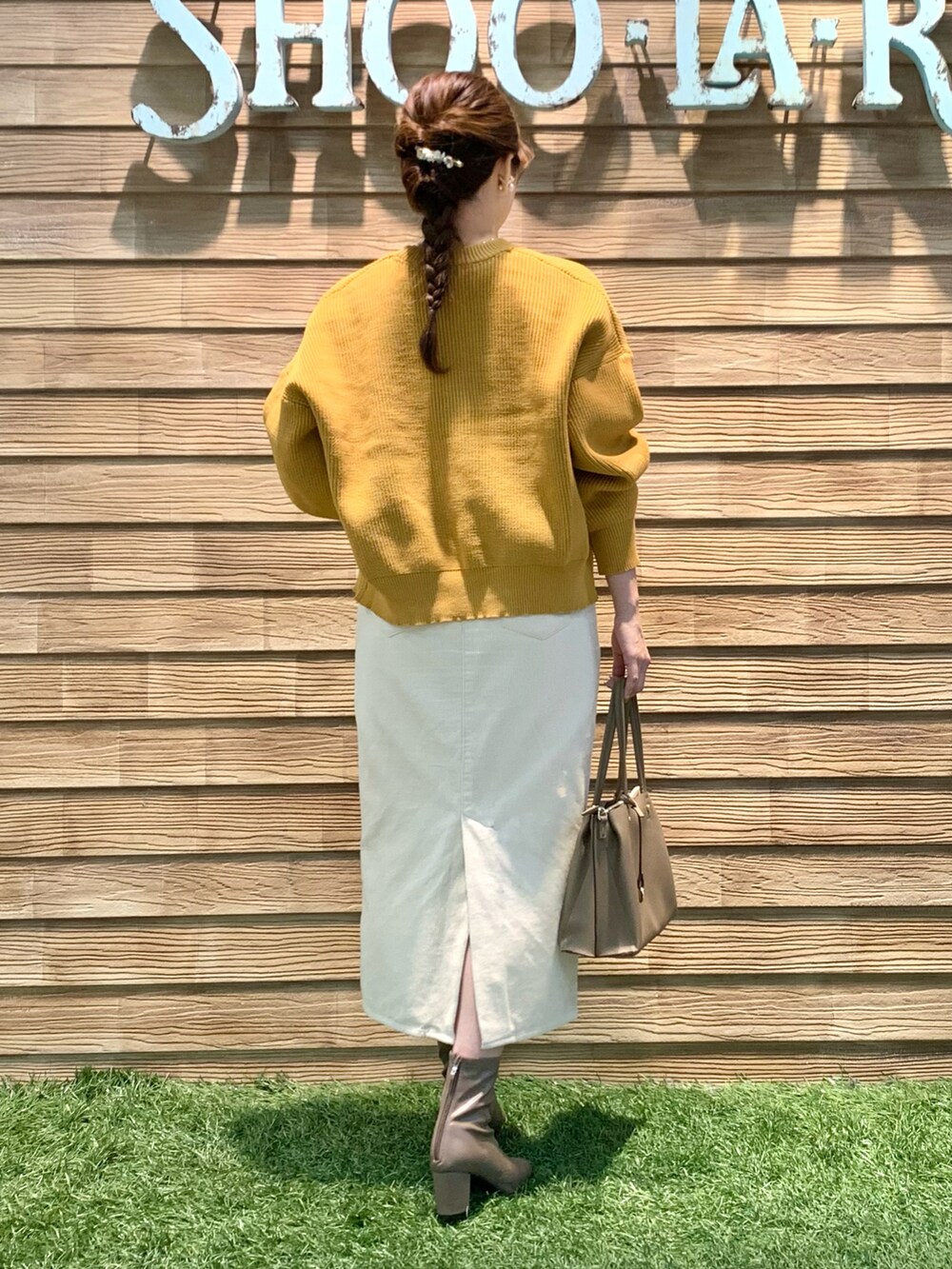 イエロー系のカーディガン/ボレロ、ホワイト系のTシャツ/カットソー、ホワイト系のスカートを着用したレディースの冬コーディネートの5枚目の写真