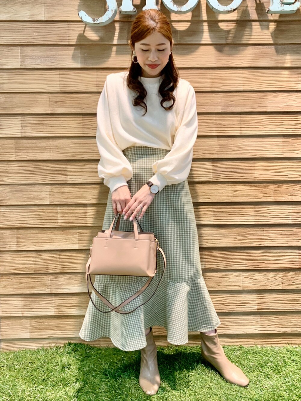 ホワイト系のTシャツ/カットソー、グリーン系のスカート、ピンク系のショルダーバッグを着用したレディースの冬コーディネートの3枚目の写真