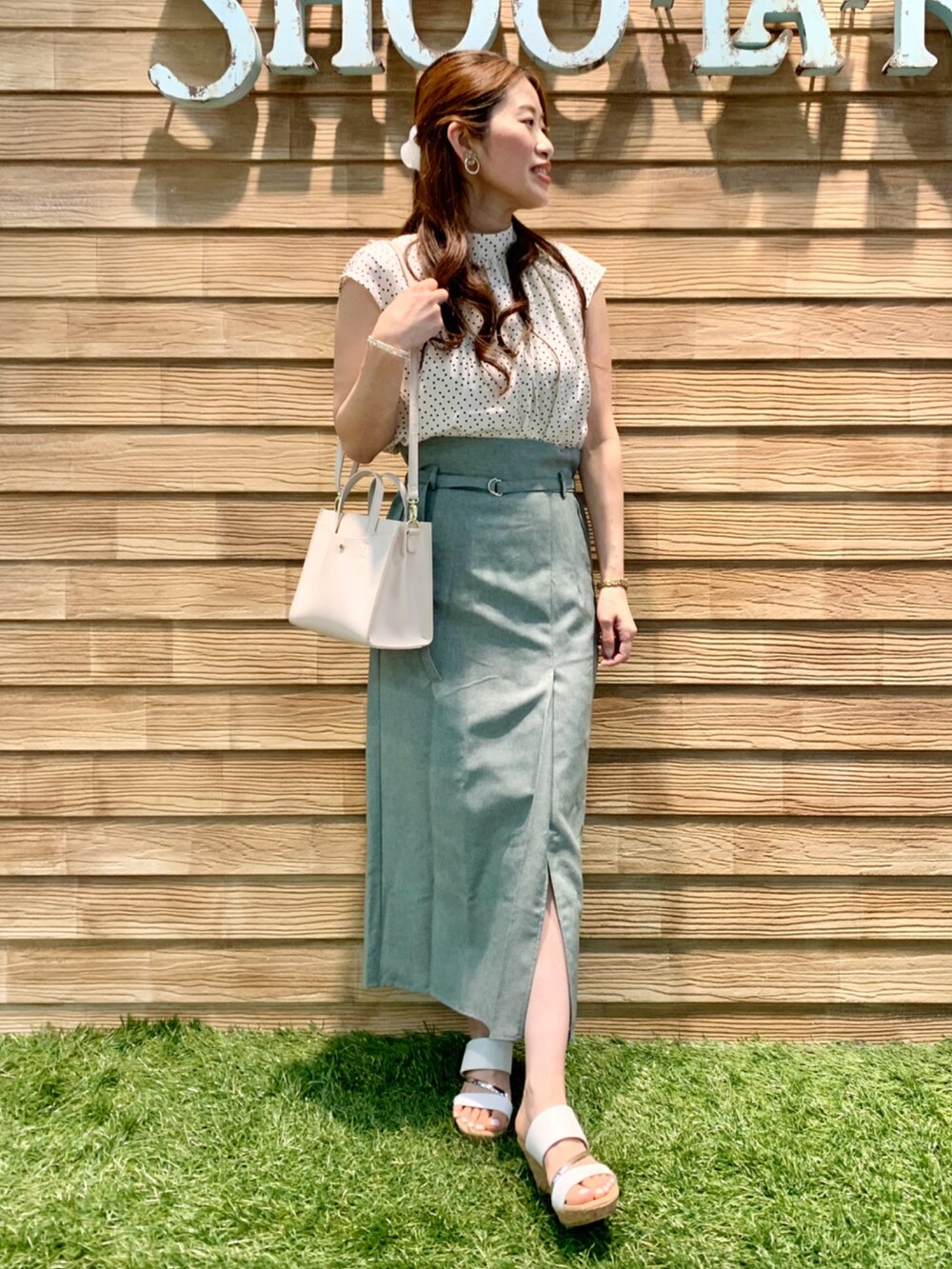 ベージュ系のシャツ/ブラウス、グリーン系のスカート、ホワイト系のショルダーバッグを着用したレディースの夏コーディネートの2枚目の写真