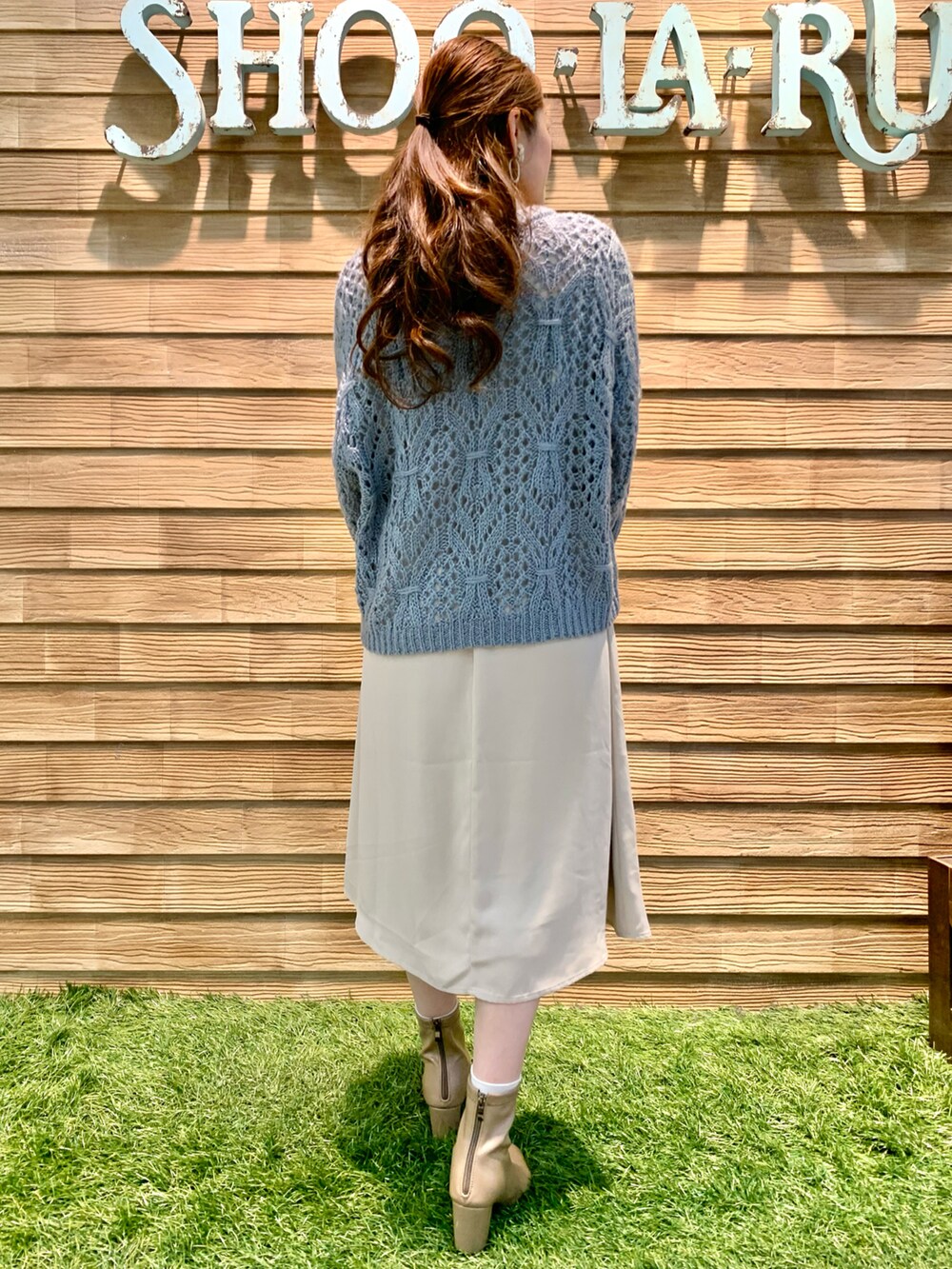 ブルー系のニット/セーター、ベージュ系のワンピース、ホワイト系のショルダーバッグを着用したレディースの冬コーディネートの4枚目の写真