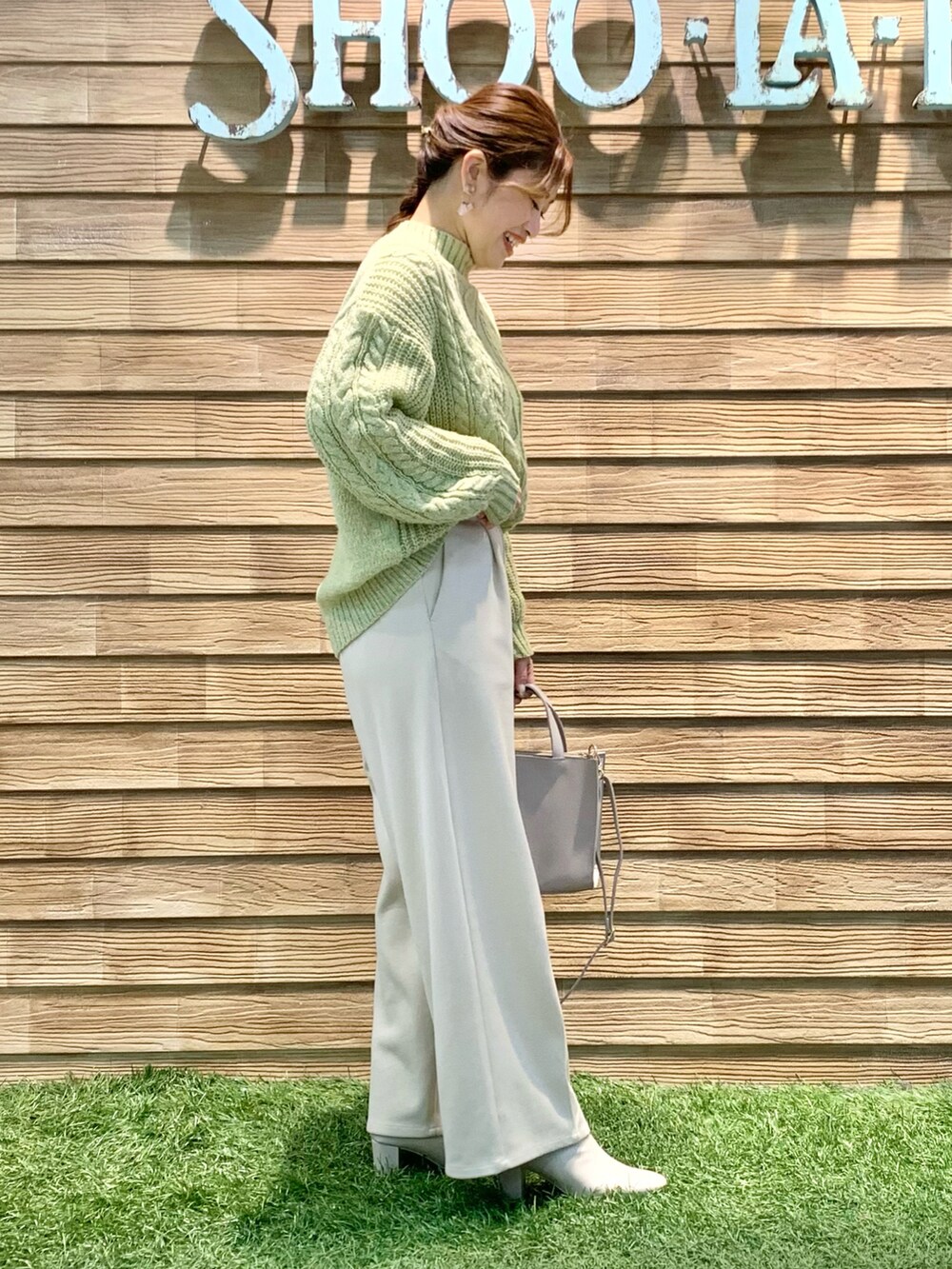 ホワイト系のダウンジャケット/コート、イエロー系のニット/セーター、ベージュ系のその他パンツを着用したレディースの冬コーディネートの4枚目の写真