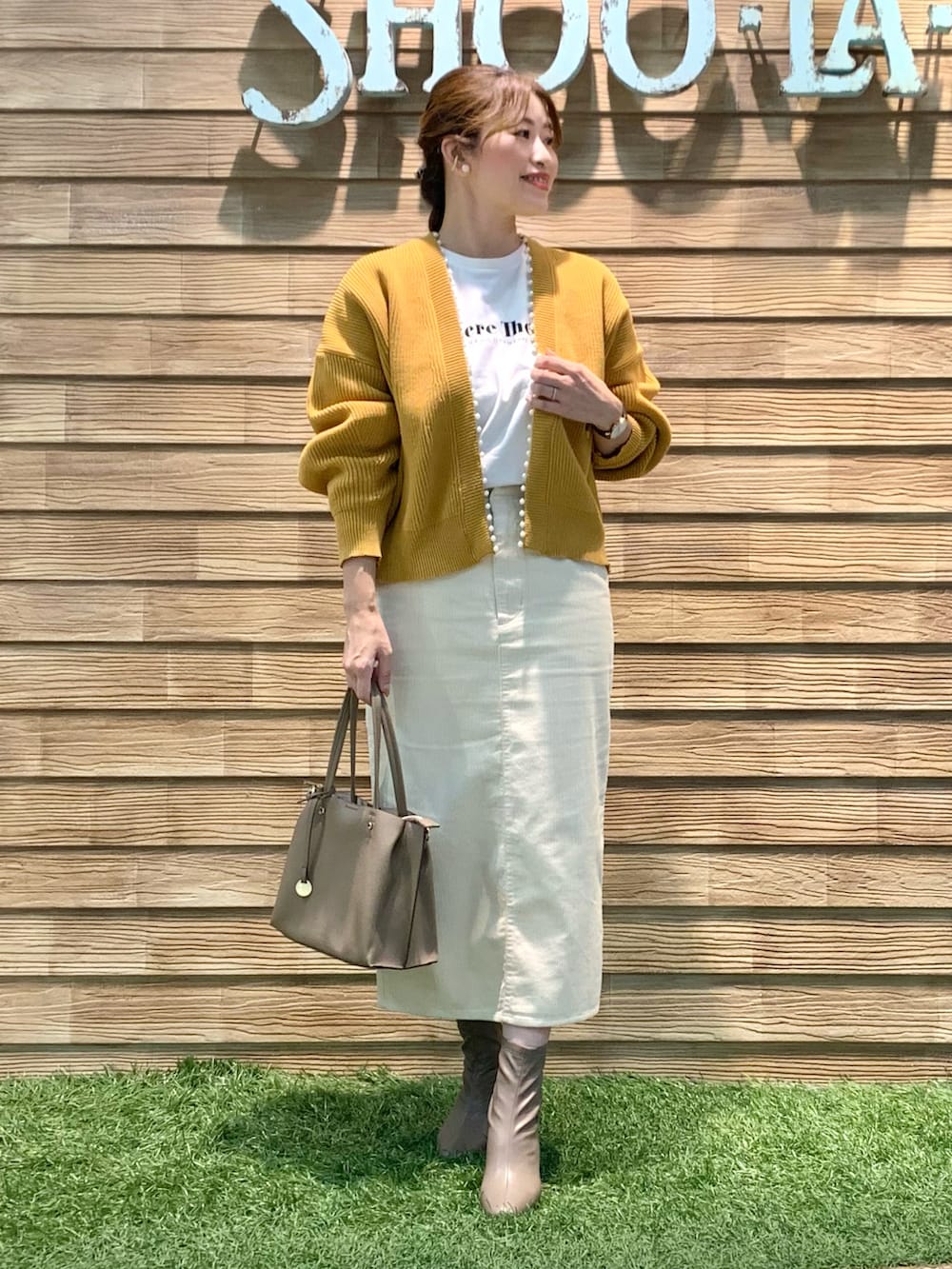 イエロー系のカーディガン/ボレロ、ホワイト系のTシャツ/カットソー、ホワイト系のスカートを着用したレディースの冬コーディネートの3枚目の写真