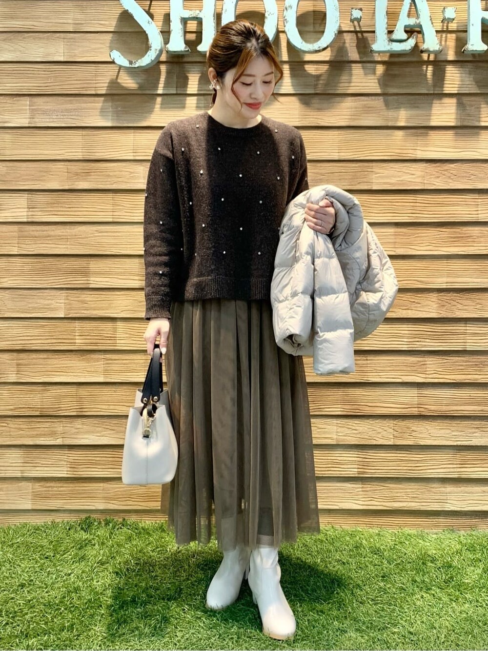 ブラウン系のスカート、ベージュ系のトートバッグを着用したレディースの冬コーディネートの5枚目の写真