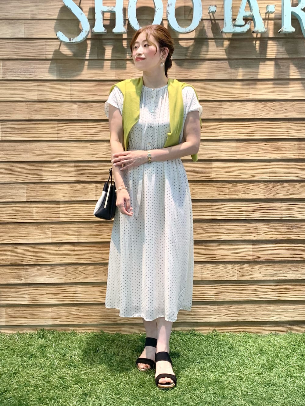 ベージュ系のワンピース、イエロー系のカーディガン/ボレロ、ブラック系のショルダーバッグを着用したレディースの夏コーディネートの2枚目の写真