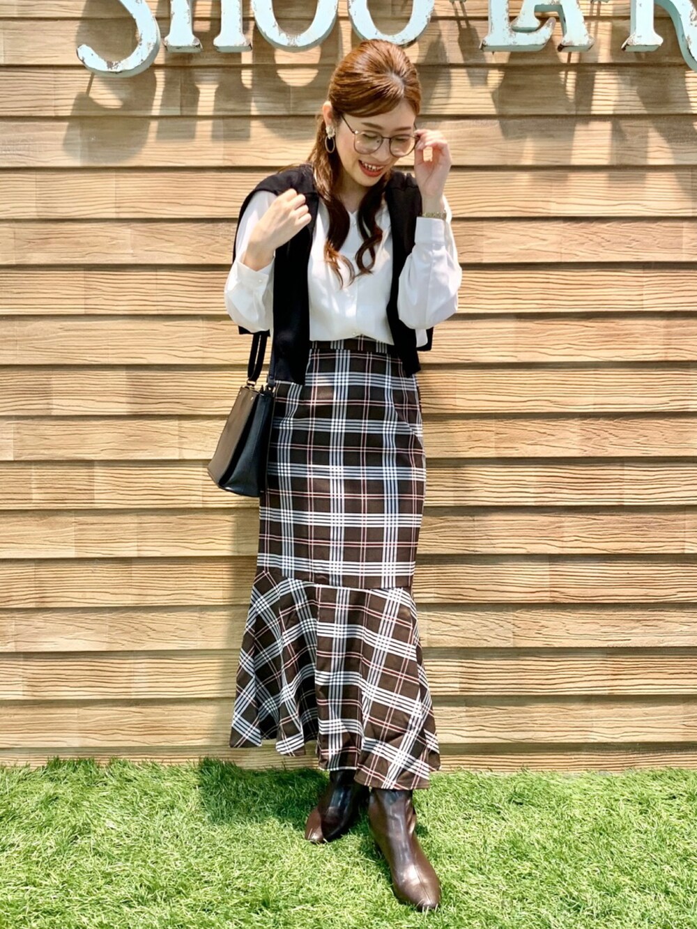 ブラック系のカーディガン/ボレロ、ホワイト系のシャツ/ブラウス、ブラウン系のスカートを着用したレディースの秋コーディネートの3枚目の写真