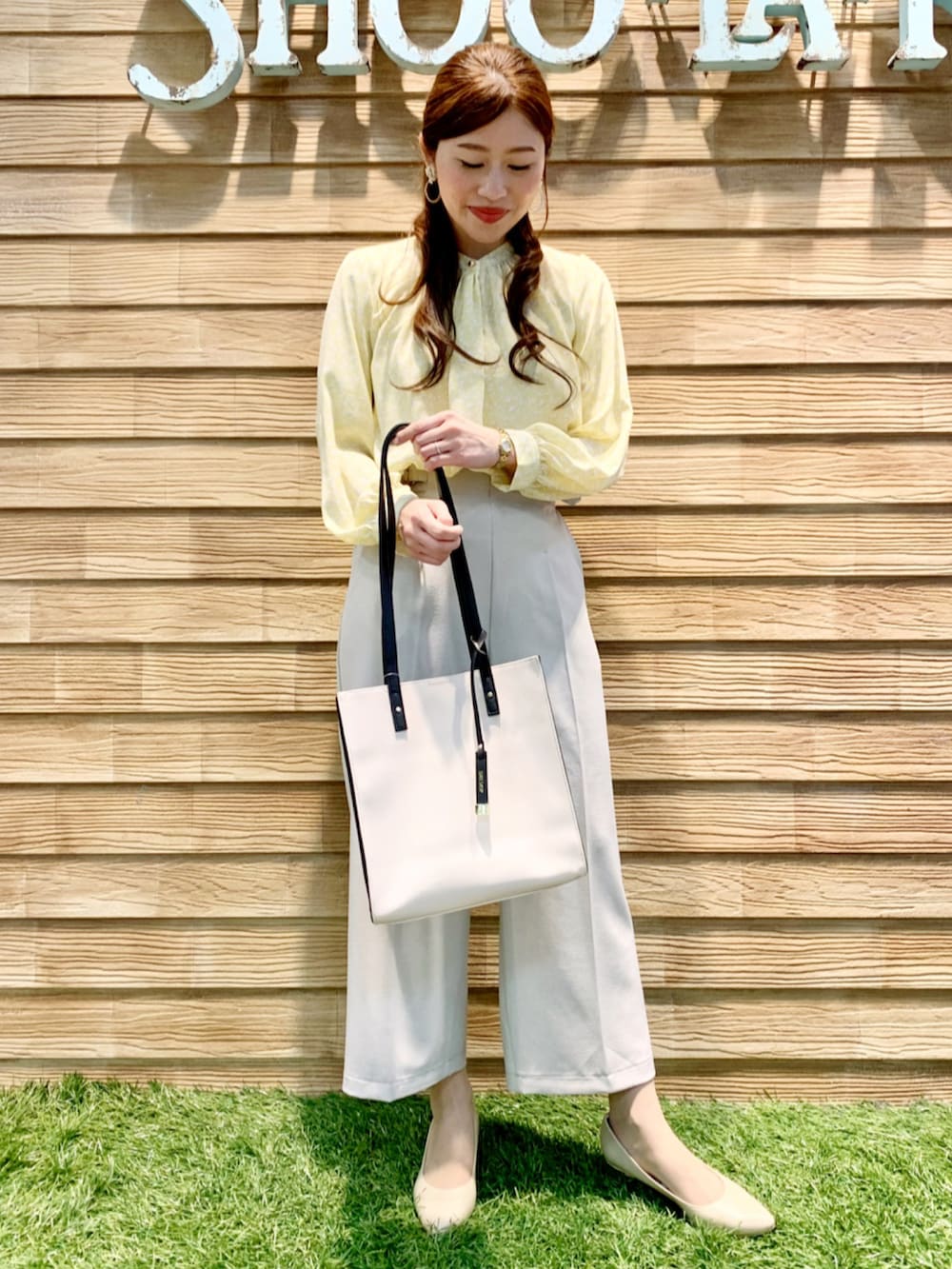 イエロー系のシャツ/ブラウス、ベージュ系のその他パンツ、ベージュ系のトートバッグを着用したレディースの春コーディネートの3枚目の写真