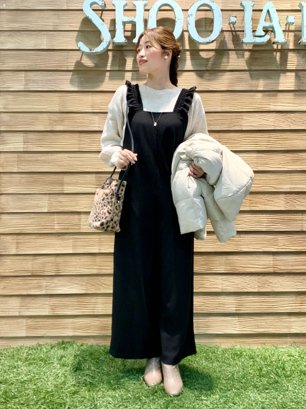 ベージュ系のダウンジャケット/コート、ベージュ系のニット/セーター、ブラック系のサロペット/オーバーオールを着用したレディースの冬コーディネートの5枚目の写真