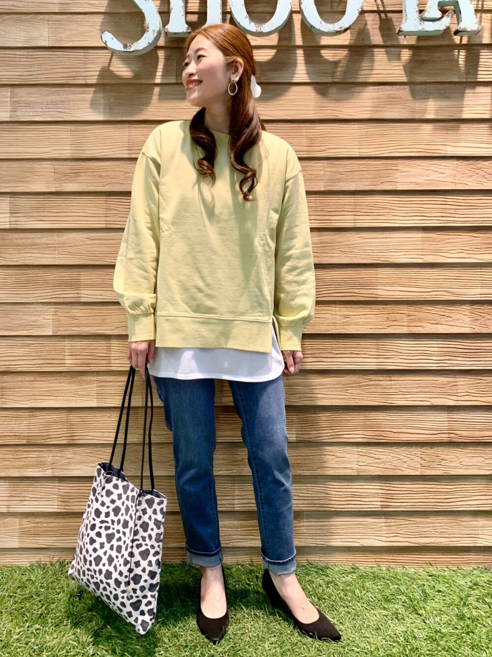 イエロー系のスウェット、ベージュ系のTシャツ/カットソー、ブルー系のデニムパンツを着用したレディースの春コーディネートの3枚目の写真