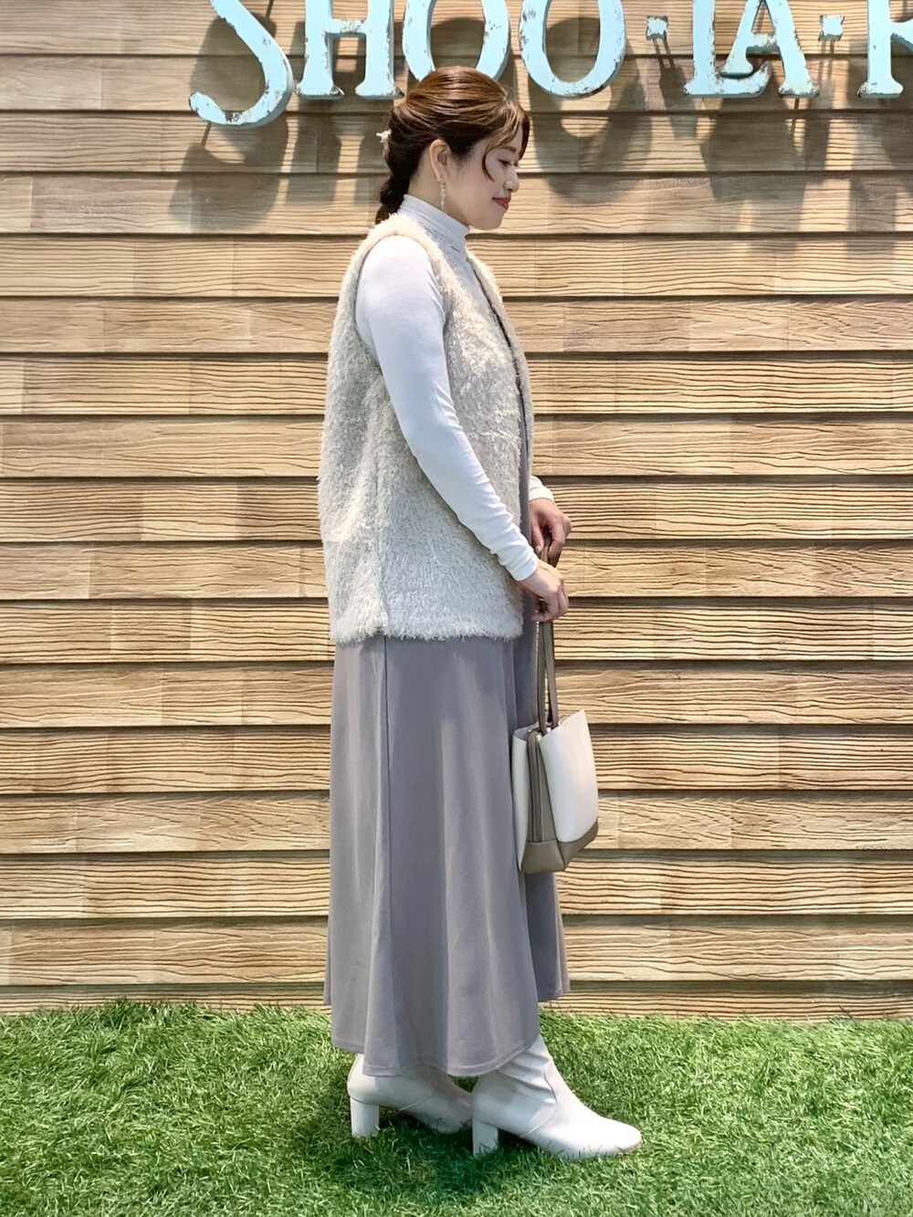 ベージュ系のベスト、ホワイト系のTシャツ/カットソー、イエロー系のワンピースを着用したレディースの春コーディネートの4枚目の写真