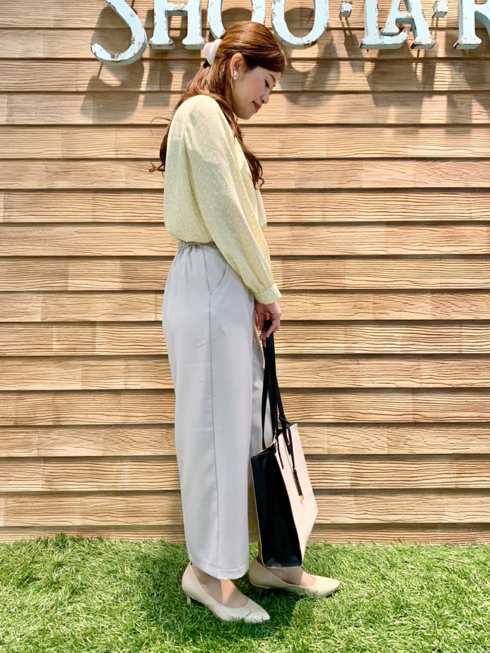 イエロー系のシャツ/ブラウス、ベージュ系のその他パンツ、ベージュ系のトートバッグを着用したレディースの春コーディネートの4枚目の写真