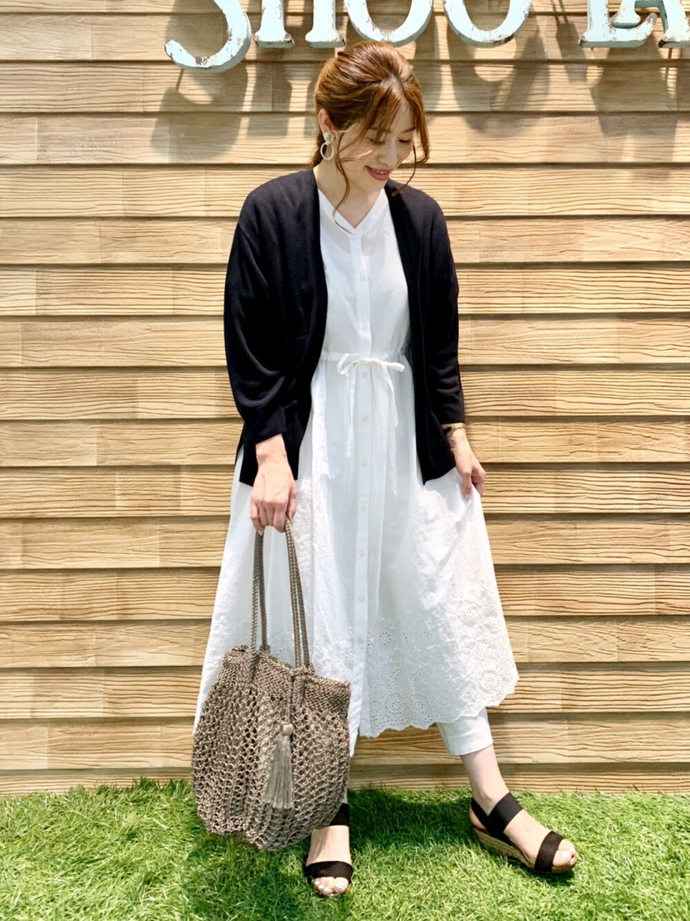ホワイト系のワンピース、ブラック系のカーディガン/ボレロ、ホワイト系のその他パンツを着用したレディースの春コーディネートの3枚目の写真