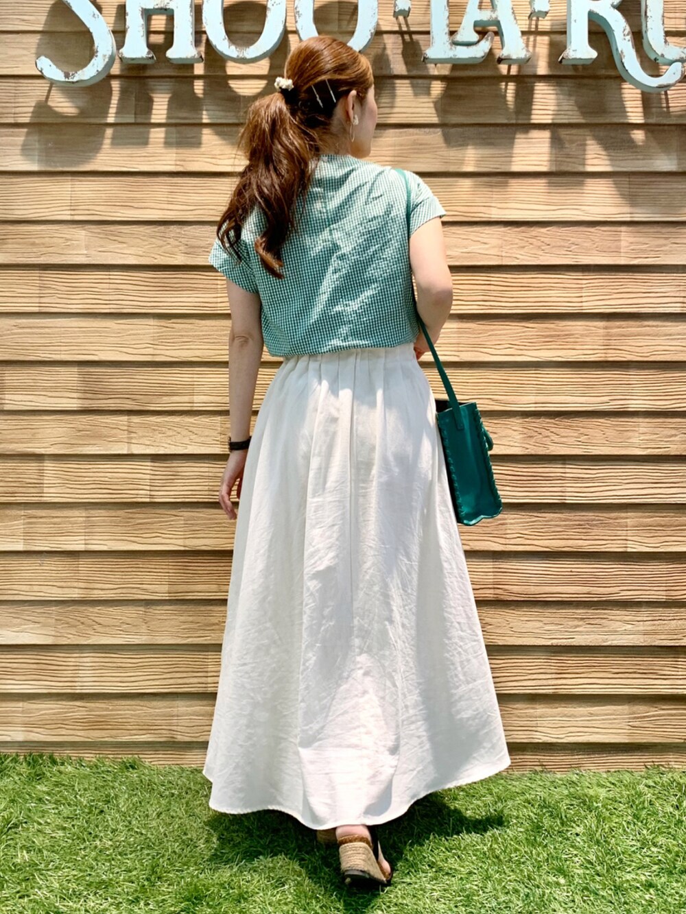 グリーン系のシャツ/ブラウス、ホワイト系のスカート、グリーン系のショルダーバッグを着用したレディースの夏コーディネートの5枚目の写真
