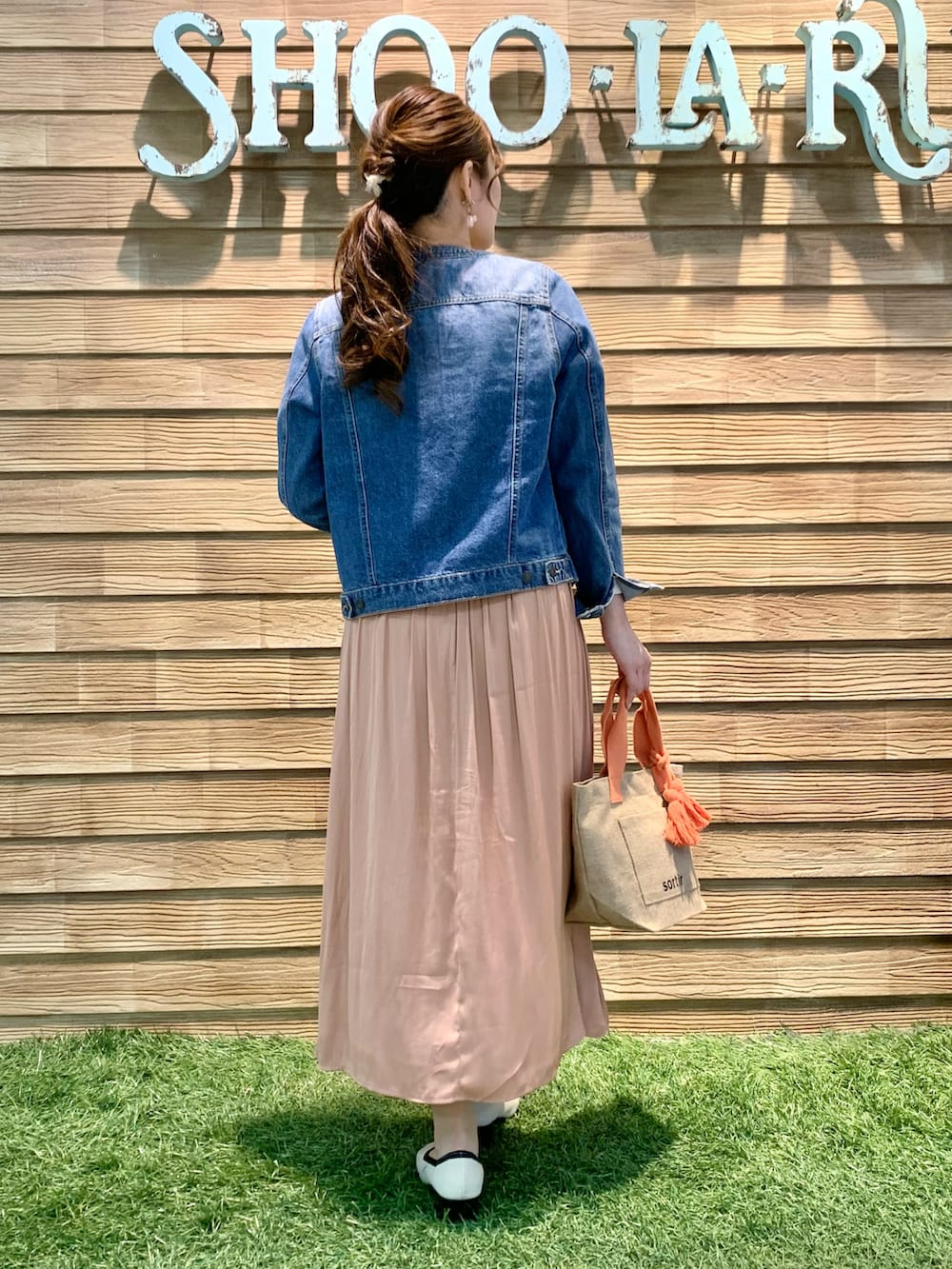 ブルー系のデニムジャケット、ベージュ系のTシャツ/カットソー、オレンジ系のスカートを着用したレディースの春コーディネートの5枚目の写真