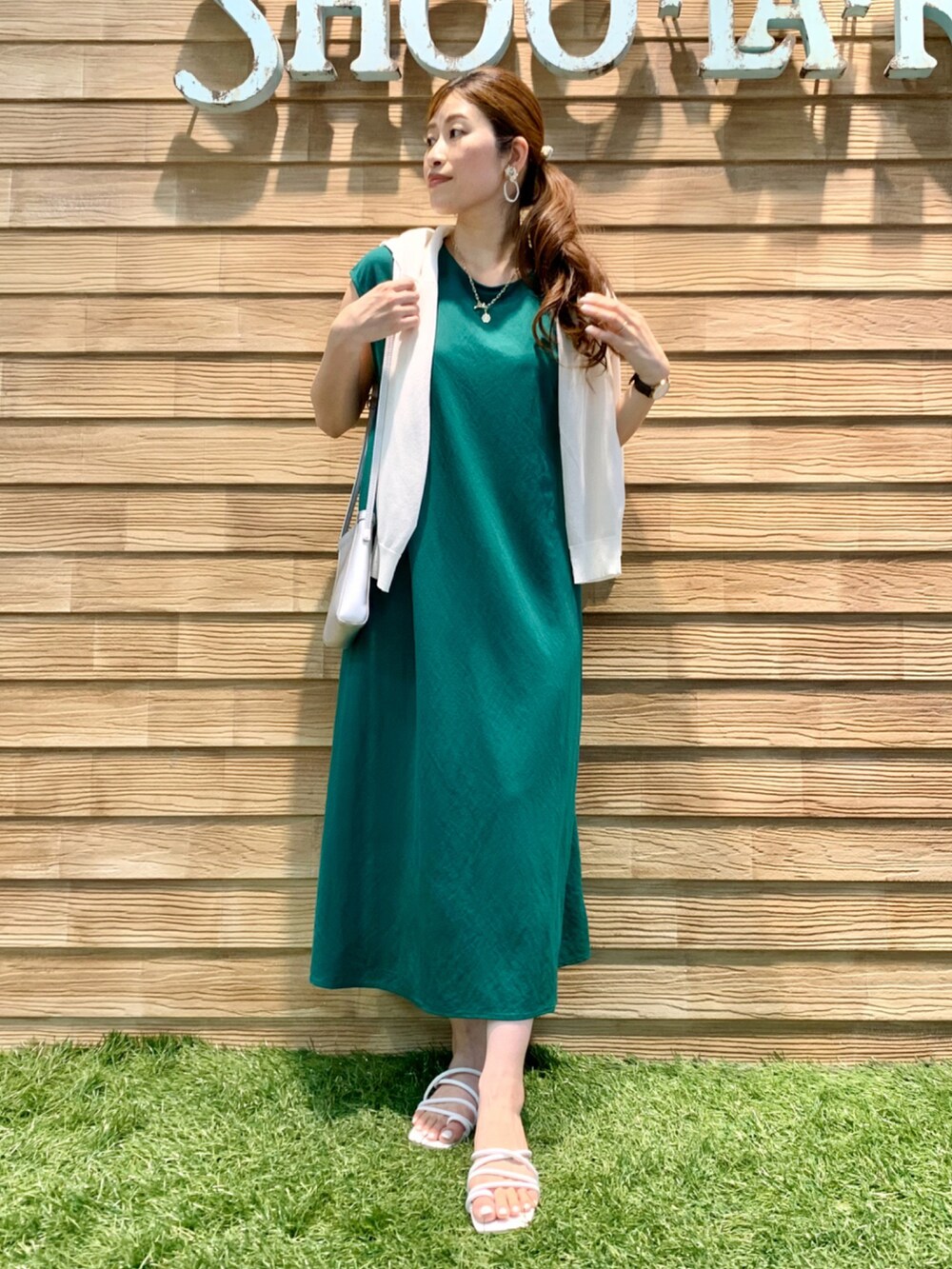 ホワイト系のカーディガン/ボレロ、グリーン系のワンピース、シルバー系のショルダーバッグを着用したレディースの夏コーディネートの3枚目の写真