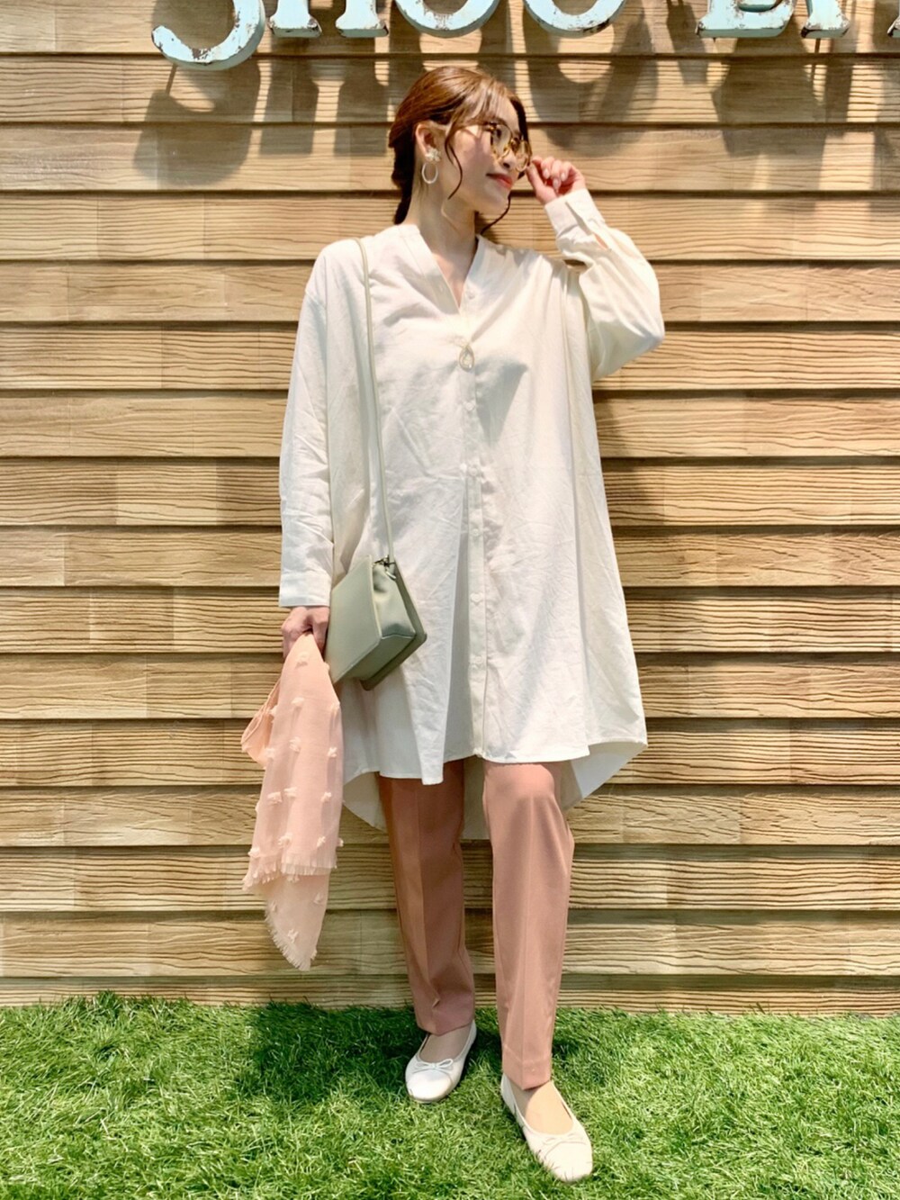 ホワイト系のワンピース、ピンク系のパンツ、グリーン系のショルダーバッグを着用したレディースの春コーディネートの2枚目の写真