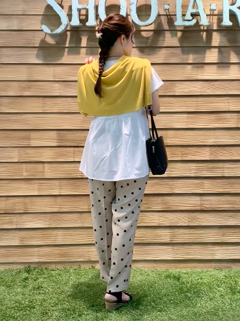 イエロー系のカーディガン/ボレロ、ホワイト系のTシャツ/カットソー、ベージュ系のその他パンツを着用したレディースの秋コーディネートの5枚目の写真