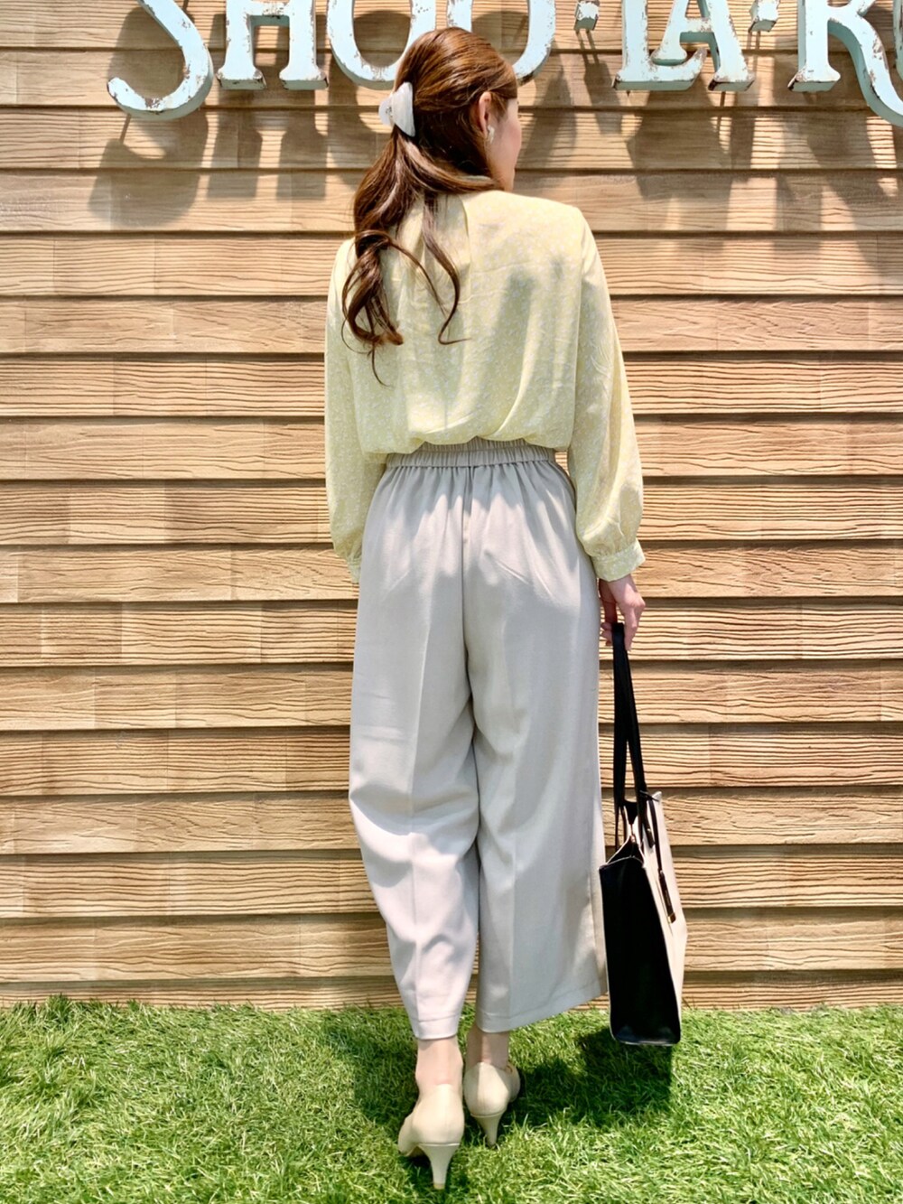 イエロー系のシャツ/ブラウス、ベージュ系のその他パンツ、ベージュ系のトートバッグを着用したレディースの春コーディネートの5枚目の写真