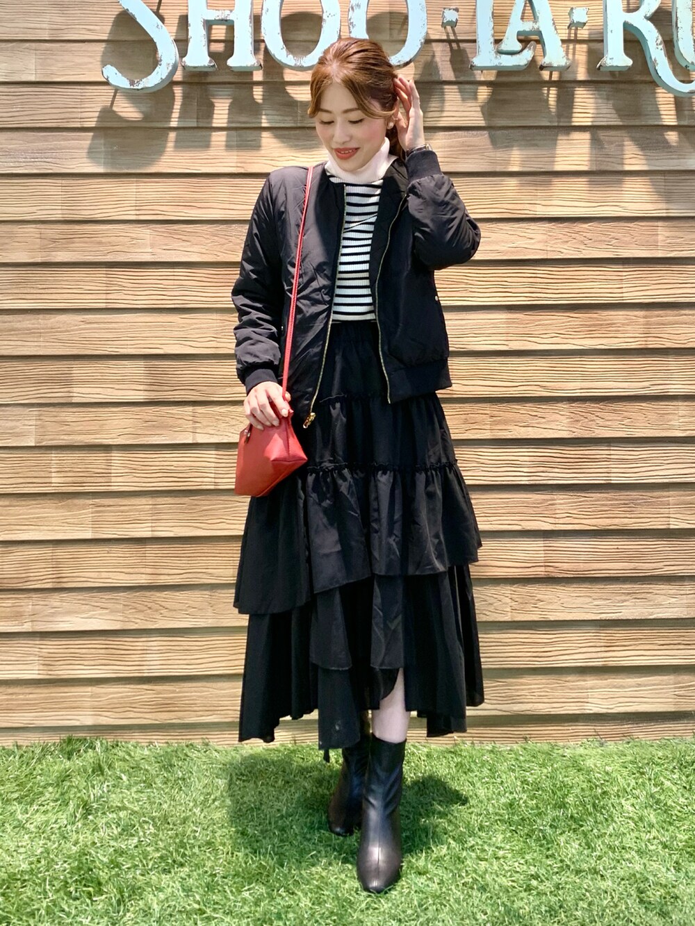 ブラック系のブルゾン、ホワイト系のニット/セーター、ブラック系のスカートを着用したレディースの秋コーディネートの3枚目の写真