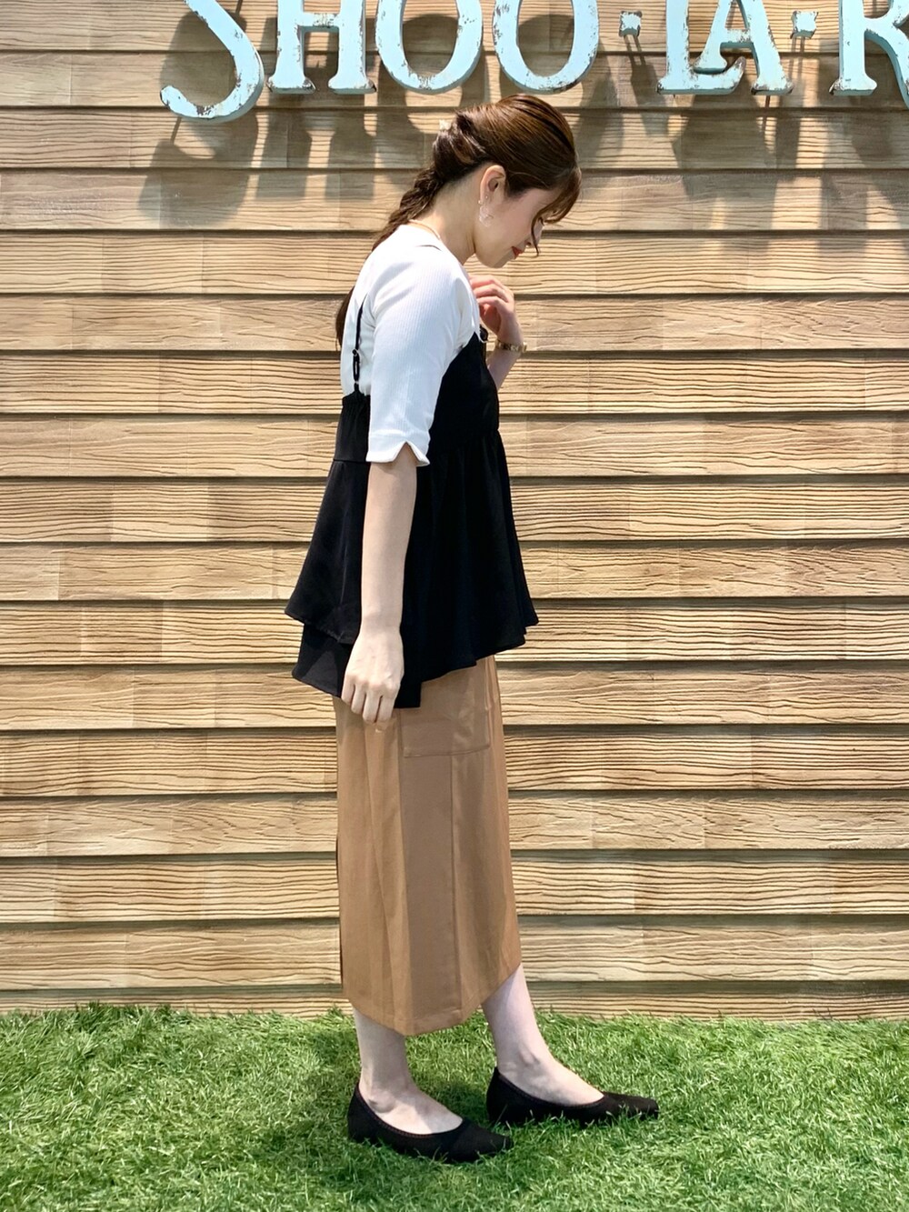 ブラック系のタンクトップ、ホワイト系のTシャツ/カットソー、イエロー系のスカートを着用したレディースの秋コーディネートの4枚目の写真