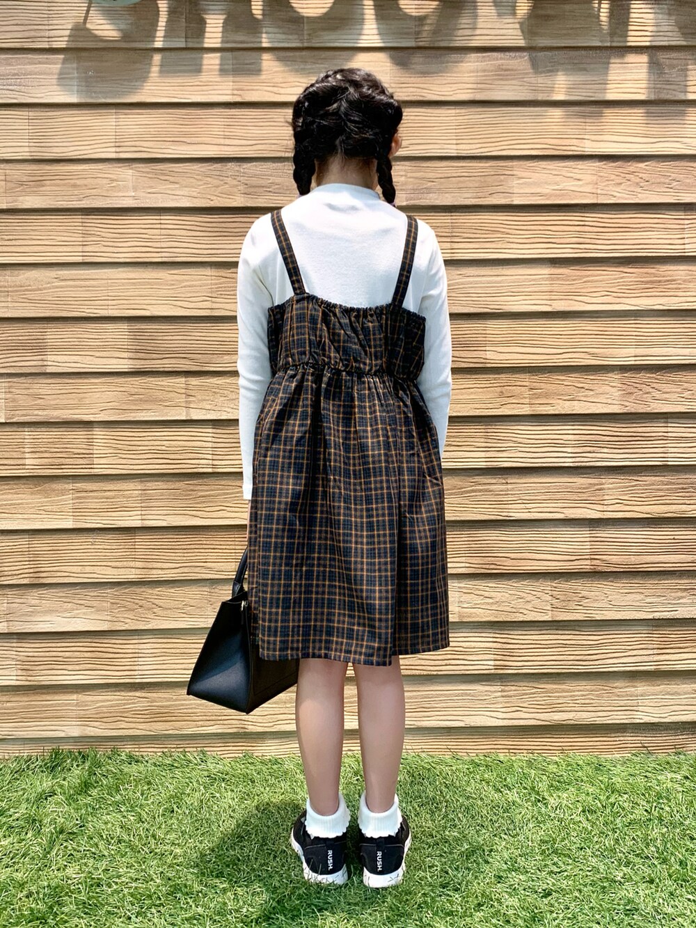 グリーン系のワンピース、ブラック系のトートバッグ、ベージュ系のブレスレットを着用したキッズの冬コーディネートの5枚目の写真
