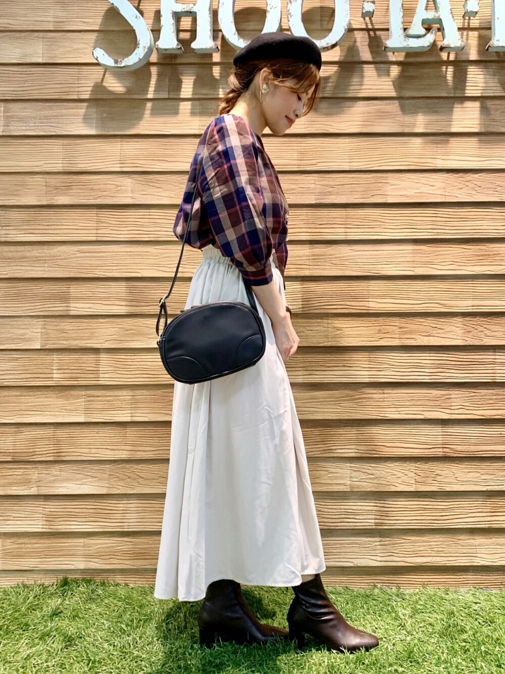 ブラウン系のシャツ/ブラウス、ホワイト系のスカート、ブラック系のショルダーバッグを着用したレディースの秋コーディネートの4枚目の写真