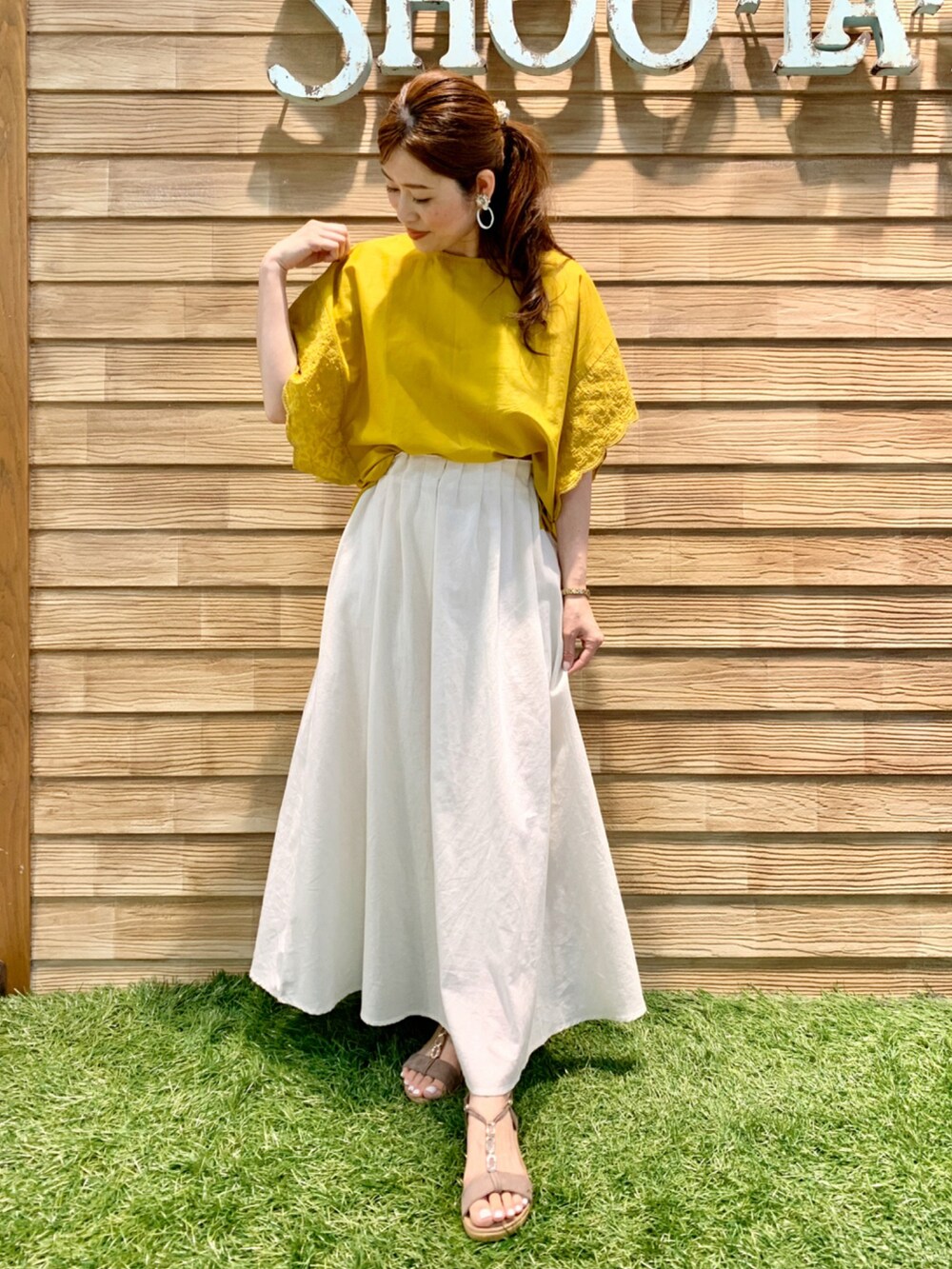 イエロー系のシャツ/ブラウス、ホワイト系のスカート、ベージュ系のサンダルを着用したレディースの夏コーディネートの3枚目の写真