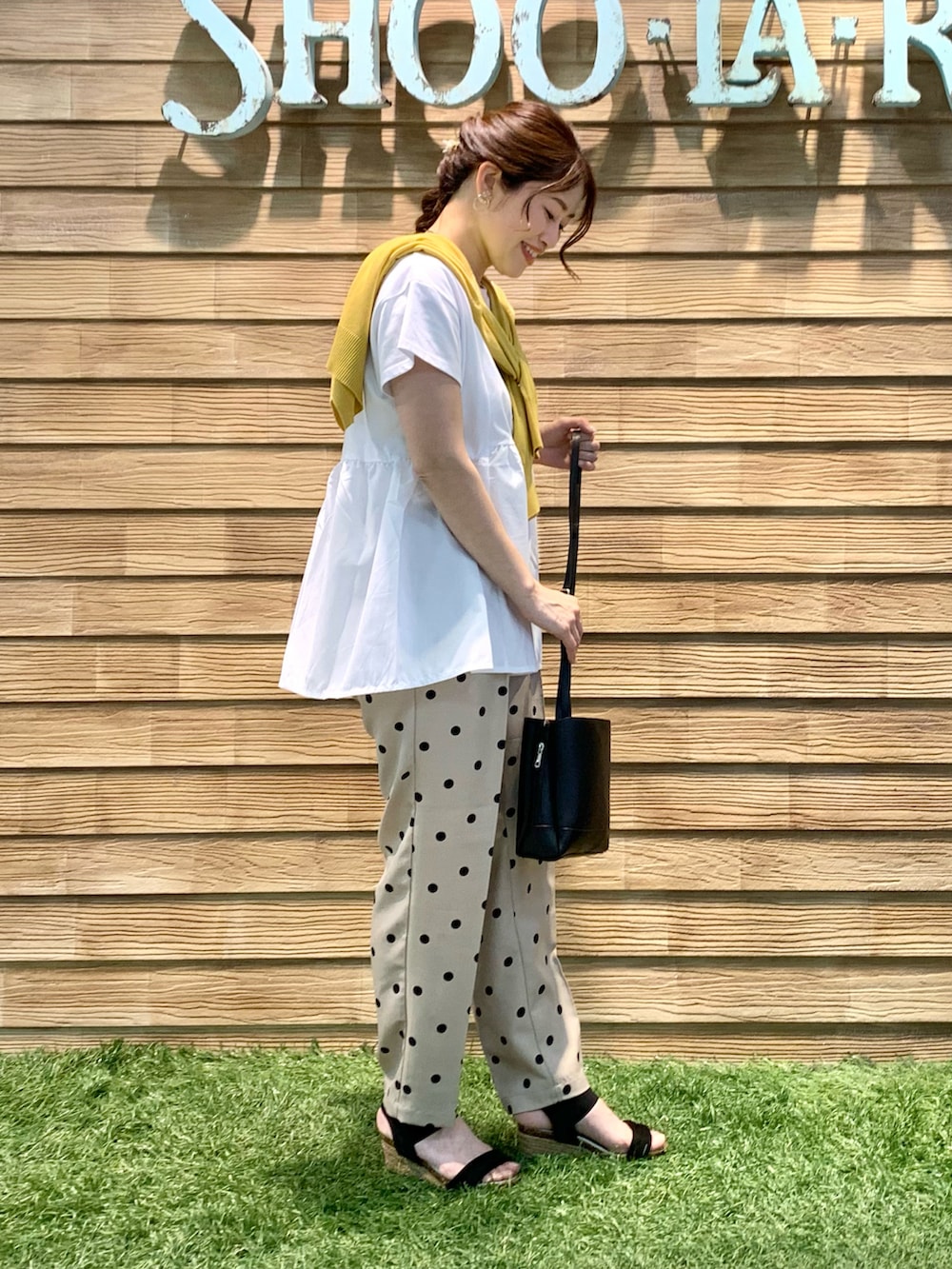 イエロー系のカーディガン/ボレロ、ホワイト系のTシャツ/カットソー、ベージュ系のその他パンツを着用したレディースの秋コーディネートの4枚目の写真