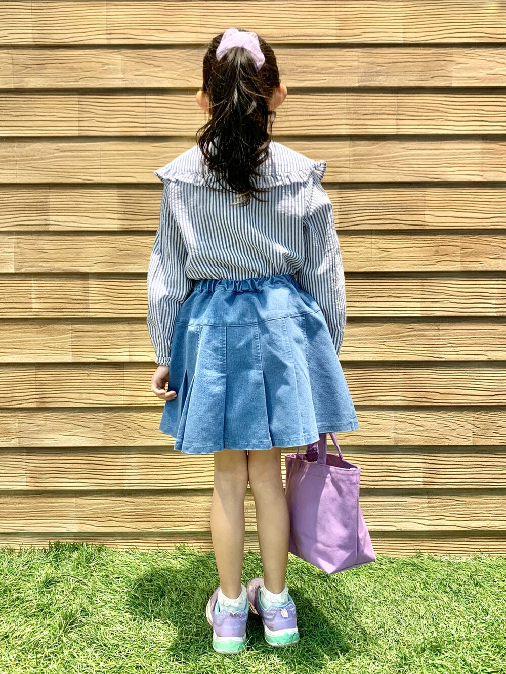 ブルー系のシャツ/ブラウス、ブルー系のデニムスカート、パープル系のトートバッグを着用したキッズの春コーディネートの4枚目の写真