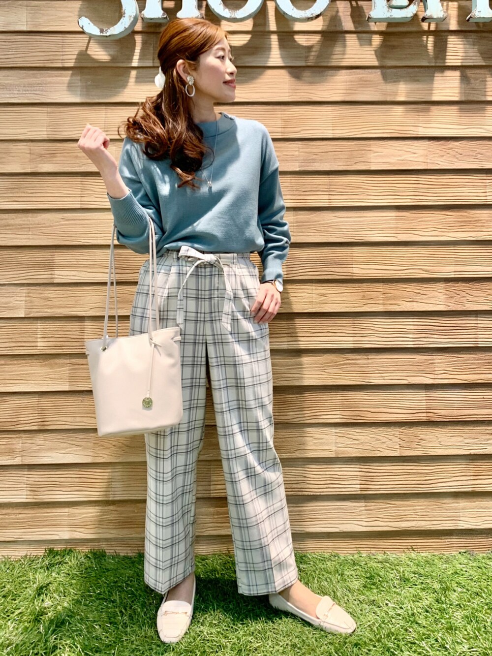 グリーン系のニット/セーター、グレー系のその他パンツ、ホワイト系のトートバッグを着用したレディースの冬コーディネートの3枚目の写真