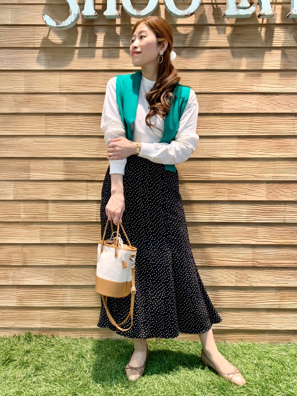 ホワイト系のTシャツ/カットソー、グリーン系のカーディガン/ボレロ、ブラック系のスカートを着用したレディースの春コーディネートの2枚目の写真
