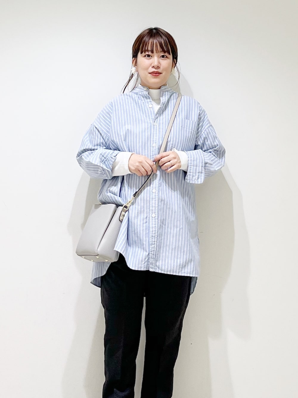 ホワイト系のTシャツ/カットソー、ブルー系のシャツ/ブラウス、グレー系のショルダーバッグを着用したレディースの秋コーディネートの6枚目の写真