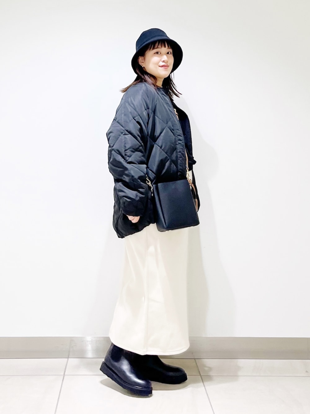 ブラック系のTシャツ/カットソー、ブラック系のその他アウター、ホワイト系のスカートを着用したレディースの秋コーディネートの4枚目の写真