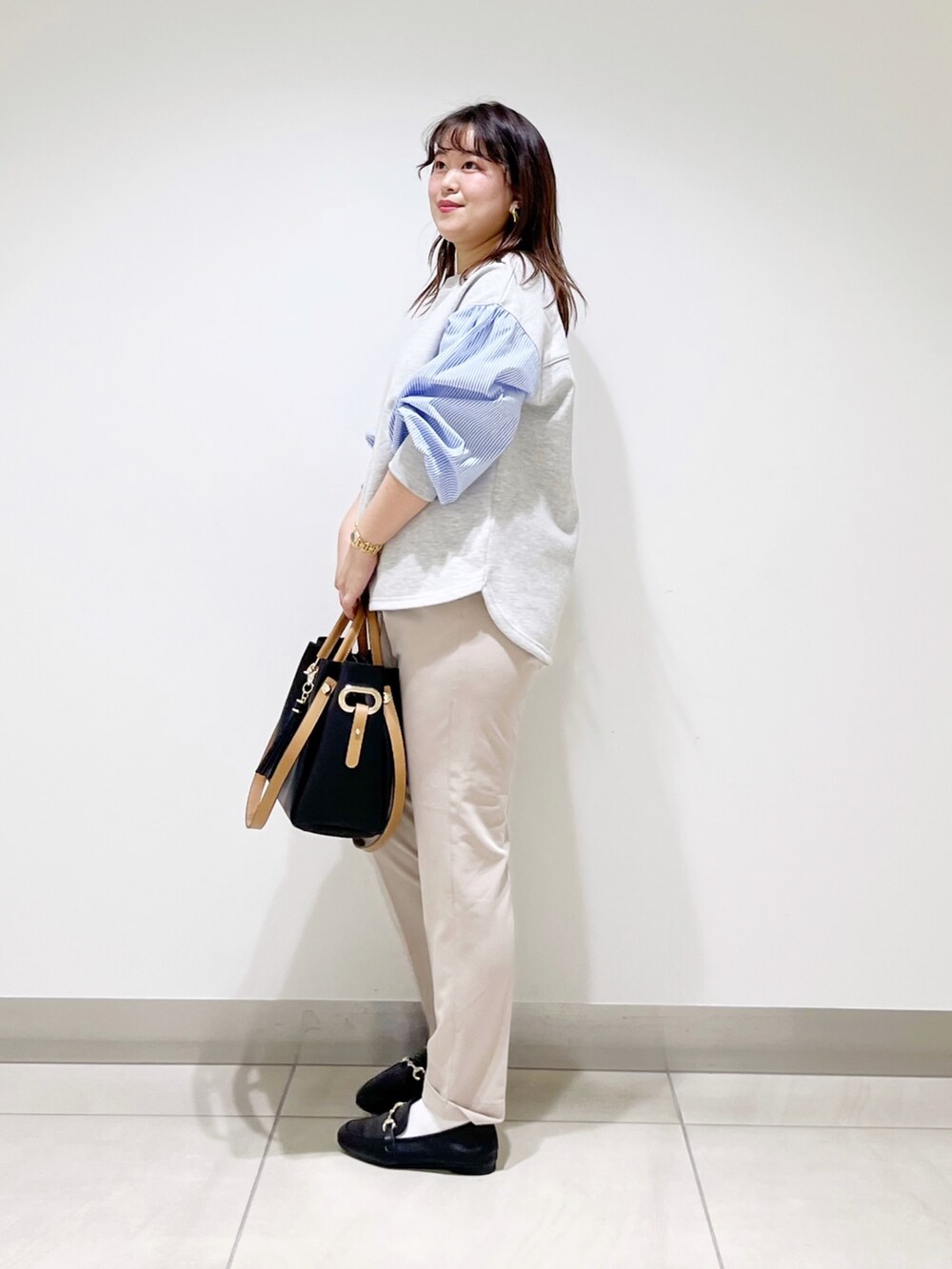 グレー系のTシャツ/カットソー、ベージュ系のその他パンツ、ブラック系のトートバッグを着用したレディースの春コーディネートの3枚目の写真