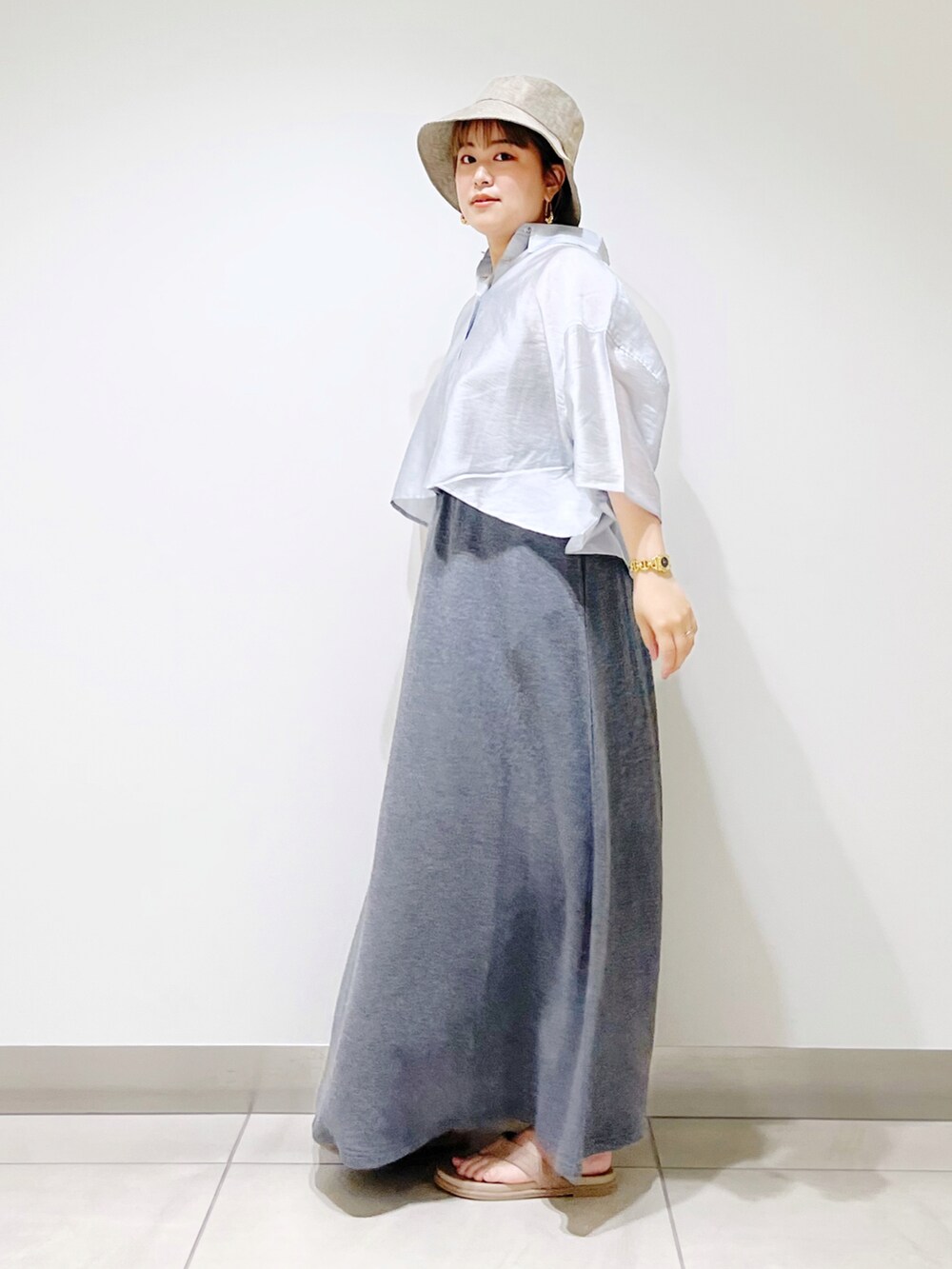 ブルー系のシャツ/ブラウス、グレー系のスカート、ベージュ系のサンダルを着用したレディースの春コーディネートの4枚目の写真