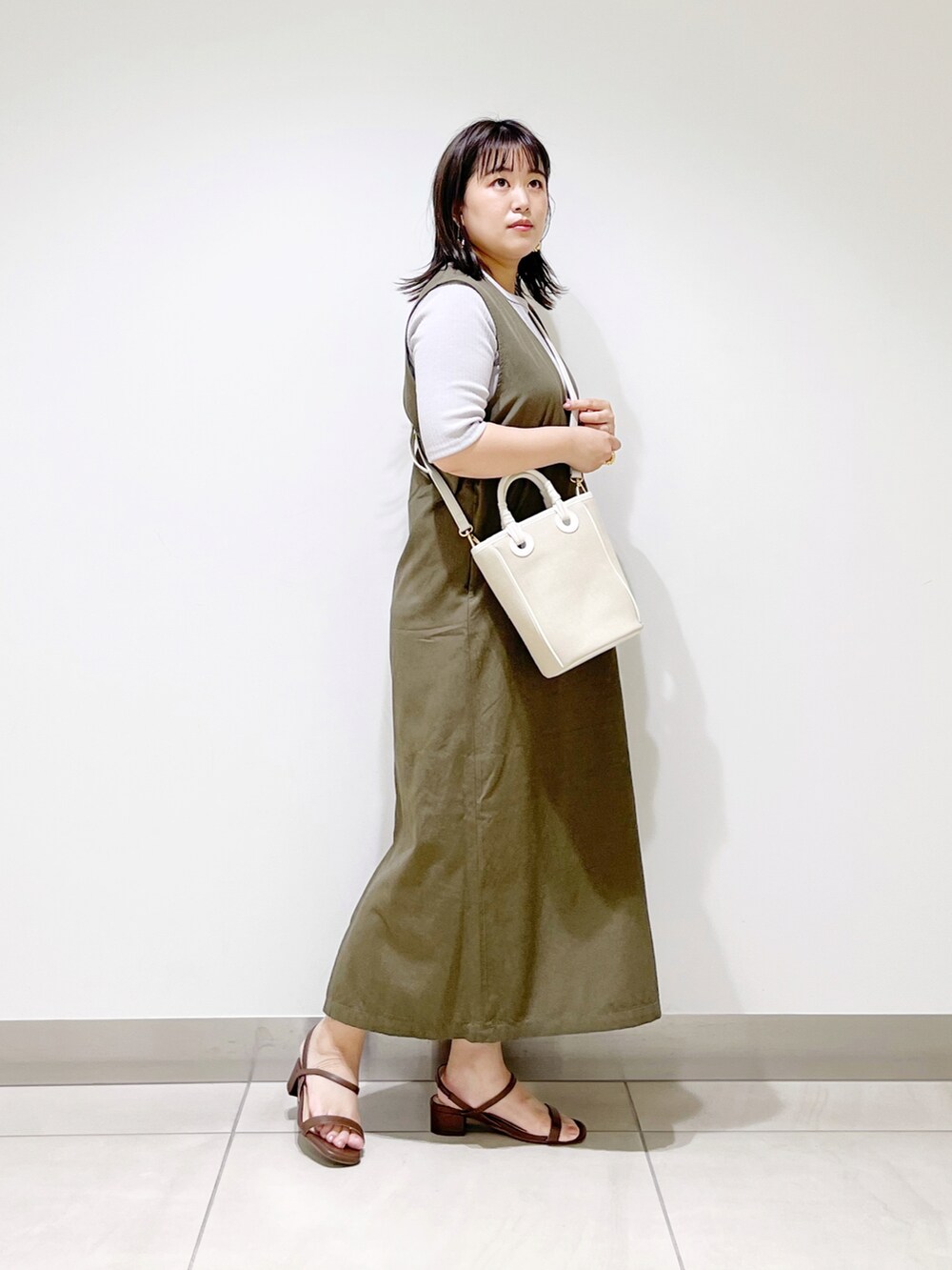 グレー系のワンピース、ベージュ系のショルダーバッグ、ブラック系のサンダルを着用したレディースの夏コーディネートの5枚目の写真