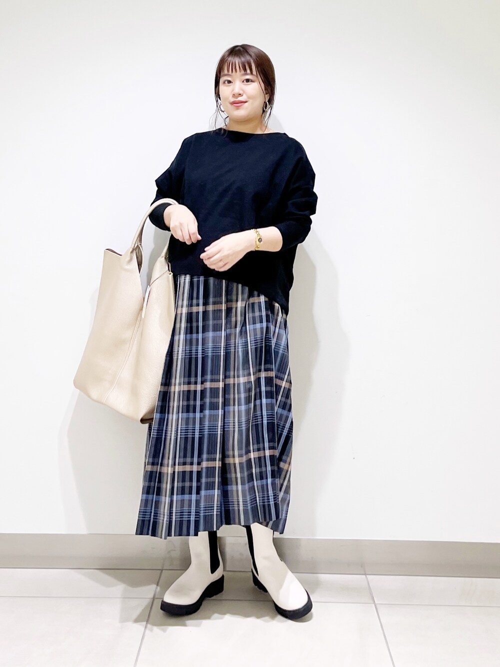 ブラック系のTシャツ/カットソー、ゴールド系のトートバッグ、ホワイト系のブーツを着用したレディースの秋コーディネートの3枚目の写真