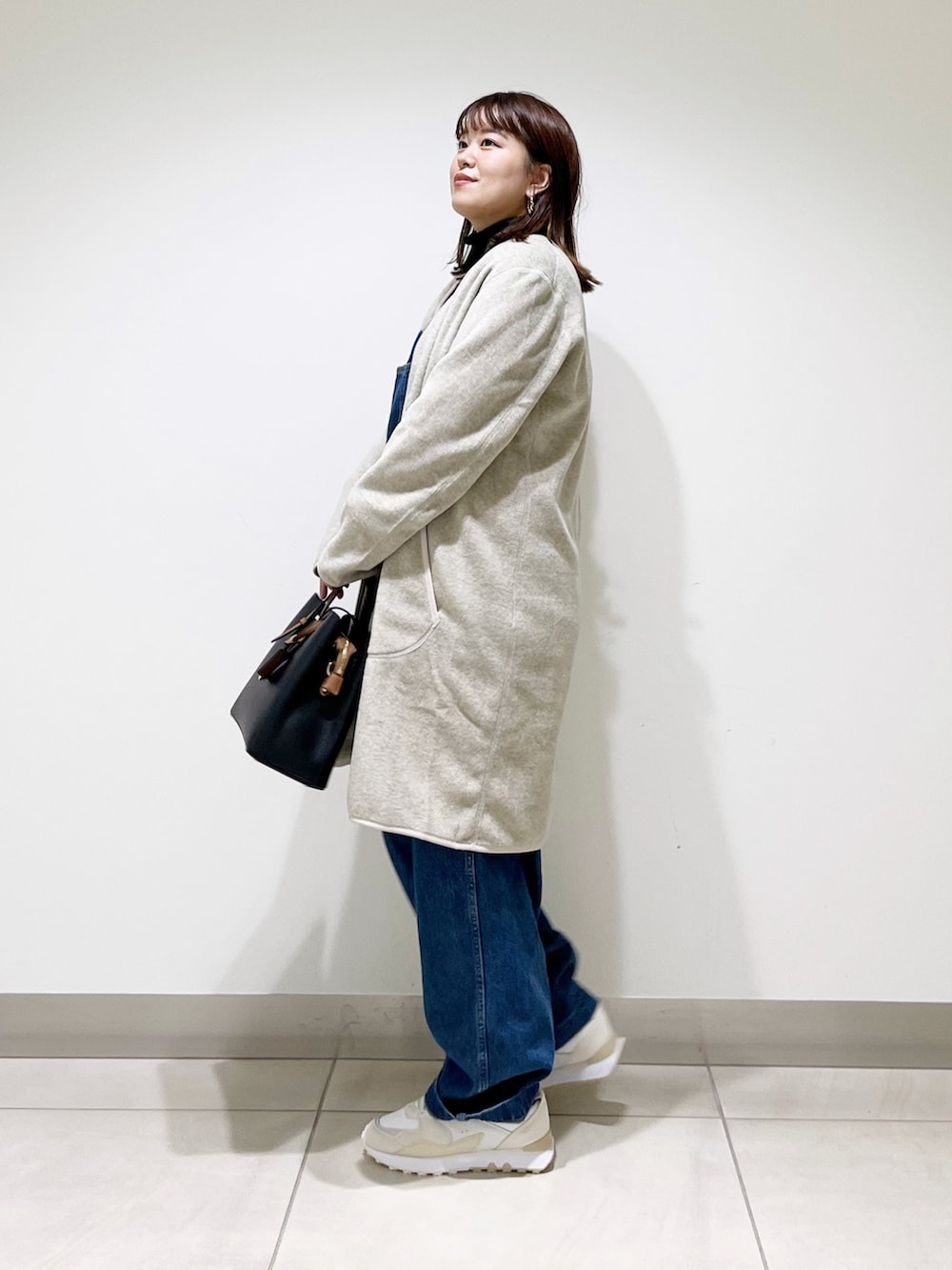 ブルー系のサロペット/オーバーオール、ベージュ系のジャケット/アウター、ブラック系のトップスを着用したレディースの秋コーディネートの7枚目の写真