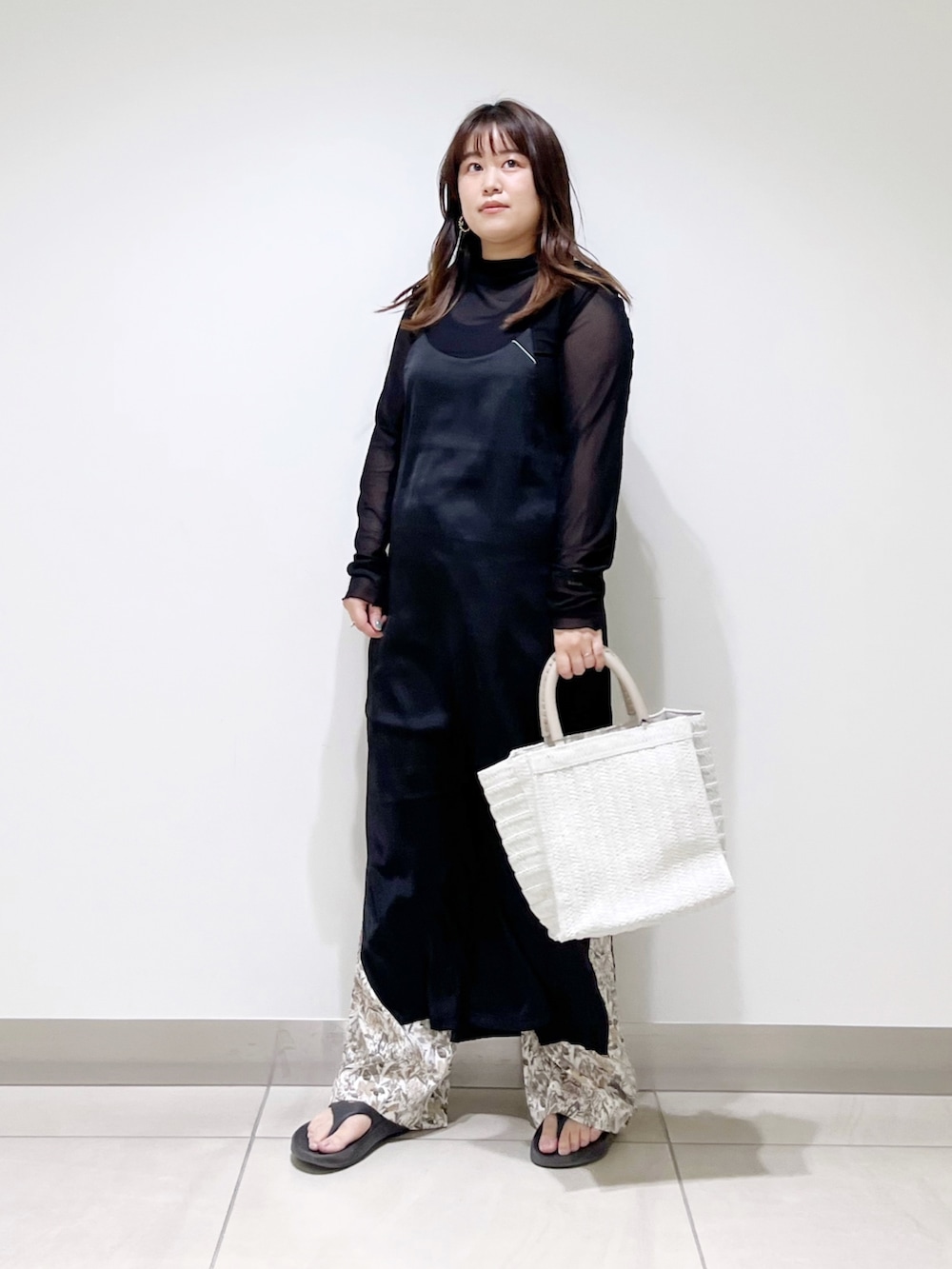 ブラック系のワンピース、ホワイト系のバッグ、ホワイト系のその他パンツを着用したレディースの春コーディネートの4枚目の写真