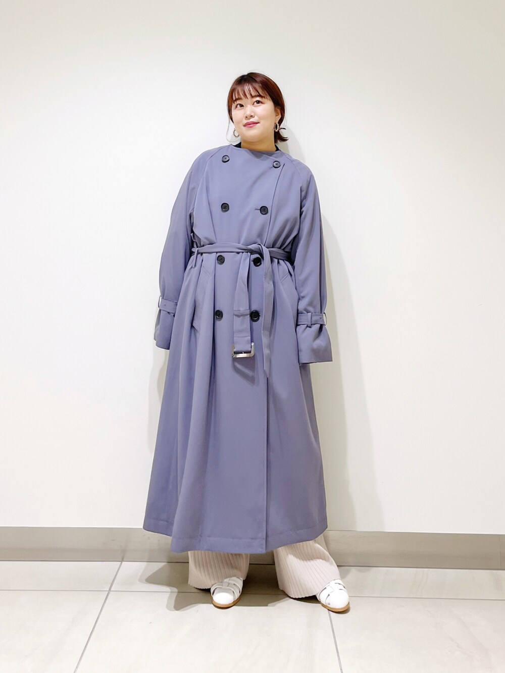 ブルー系のトレンチコート、ホワイト系のサンダル、ベージュ系のその他パンツを着用したレディースの冬コーディネートの2枚目の写真