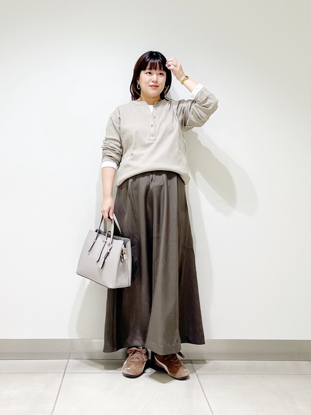 ベージュ系のTシャツ/カットソー、ブラウン系のスカート、グレー系のトートバッグを着用したレディースの秋コーディネートの8枚目の写真